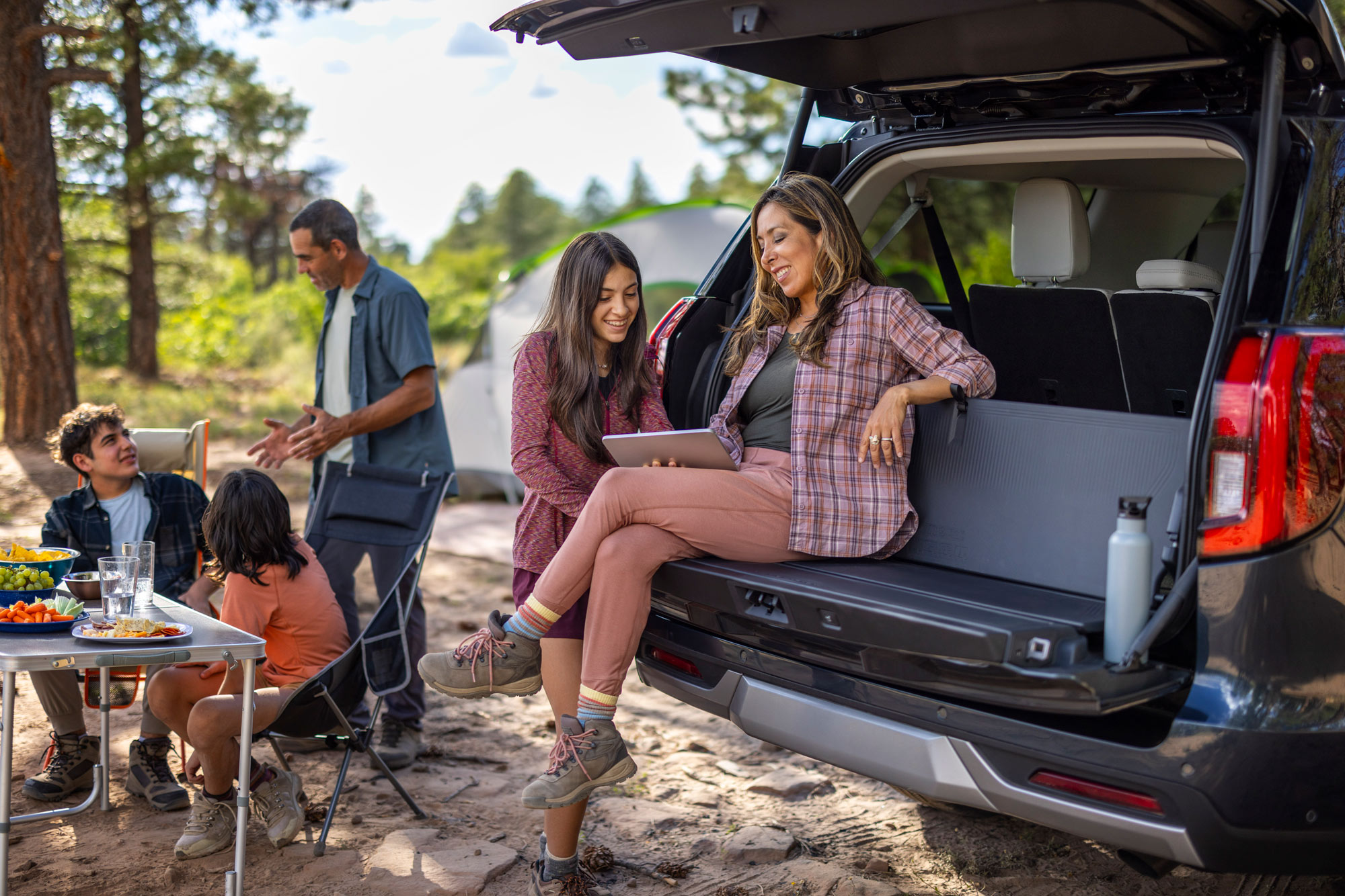 People camping near the tailgate of a 2025 Ford Expedition