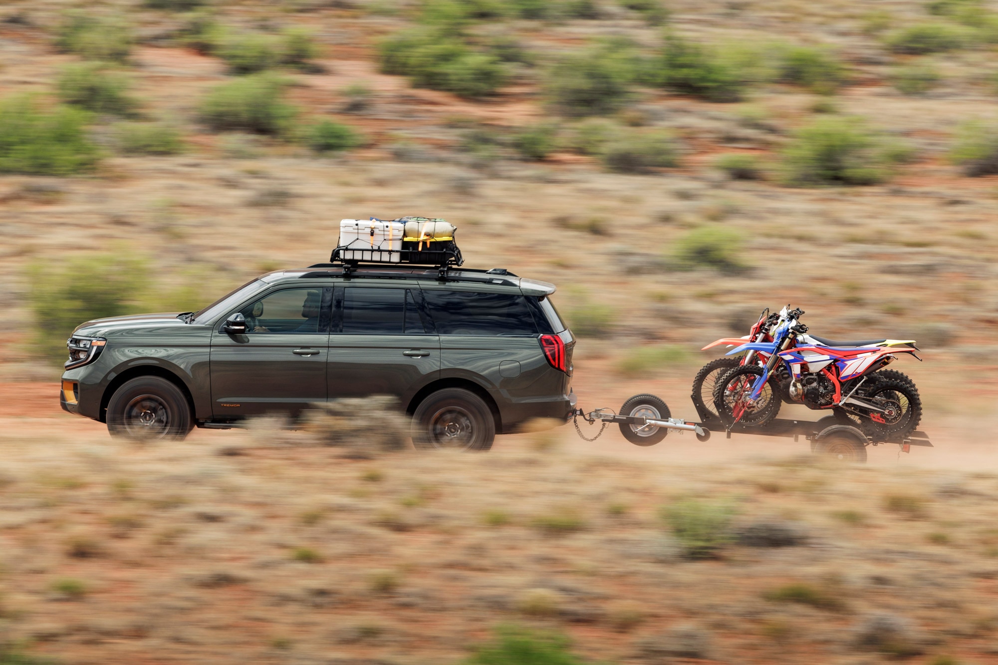 A green 2025 Ford Expedition towing two motorcycles