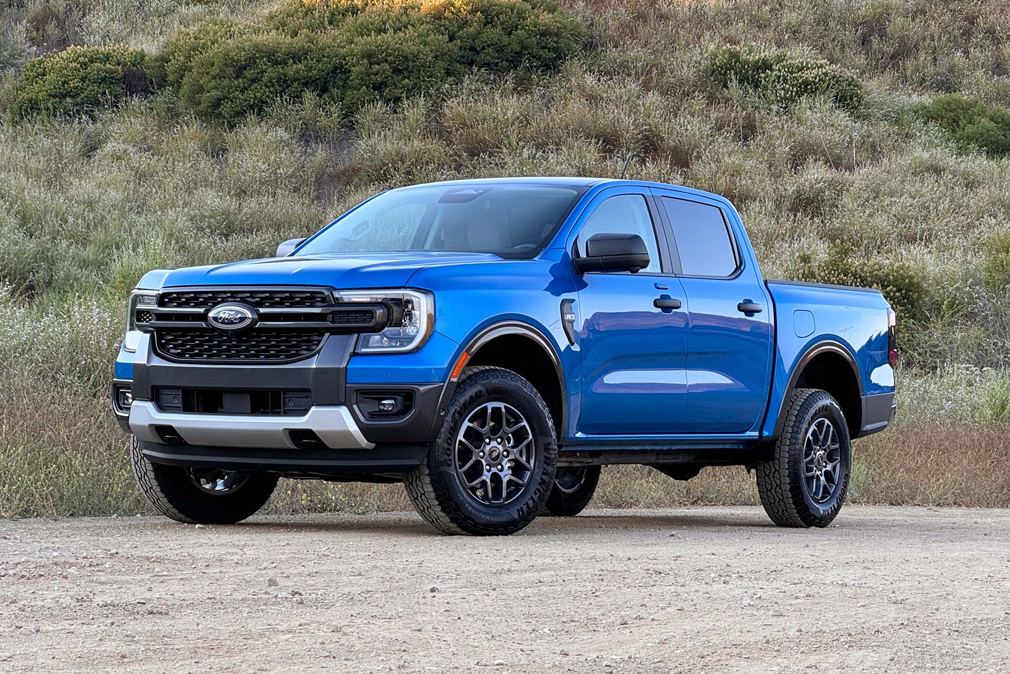 2024 Ford Ranger XLT SuperCrew in Velocity Blue Metallic parked on dirt, front-left view