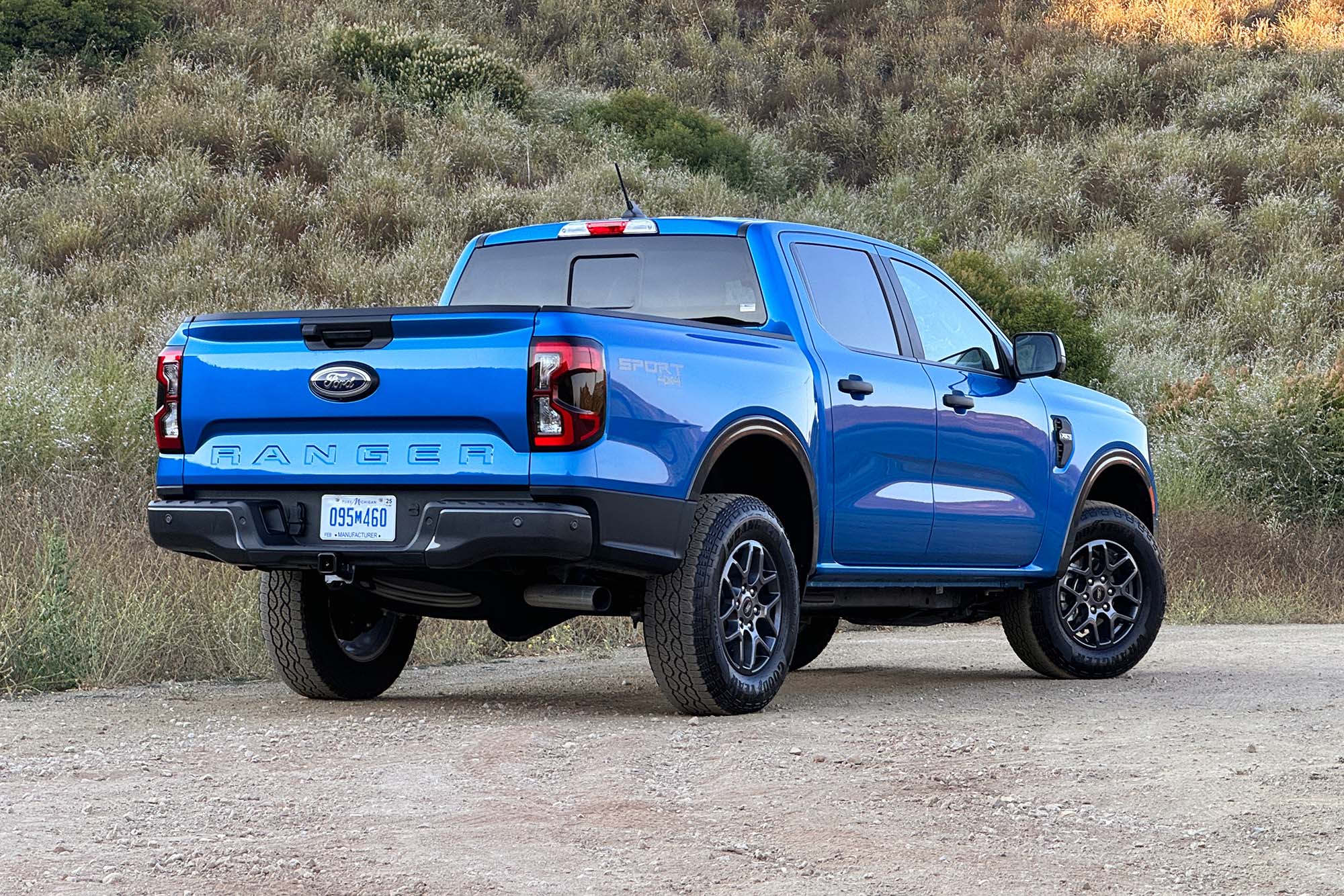 2024 Ford Ranger XLT SuperCrew in Velocity Blue Metallic parked on dirt, rear-right view