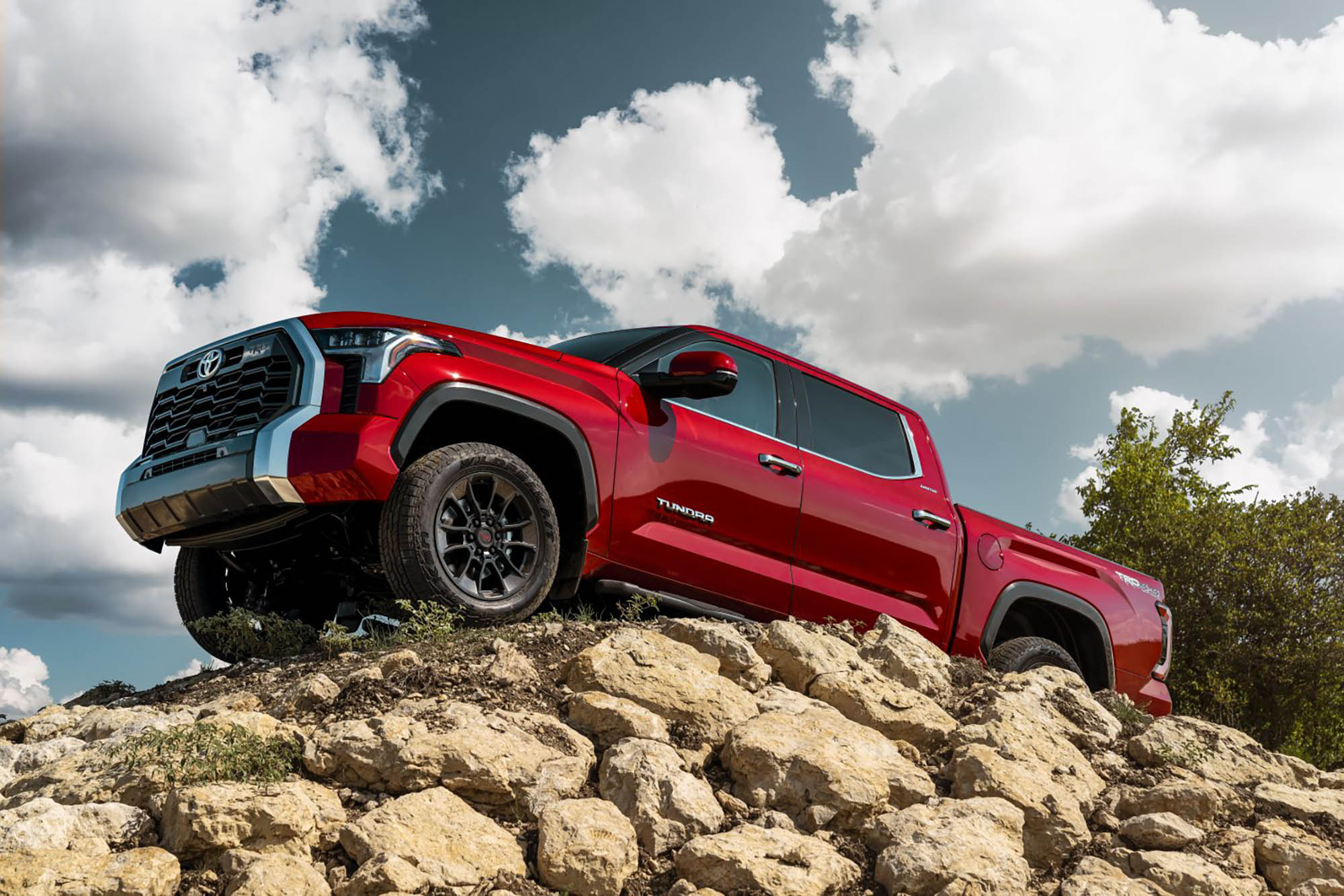 Red Toyota Tundra parked on a rocky peak.