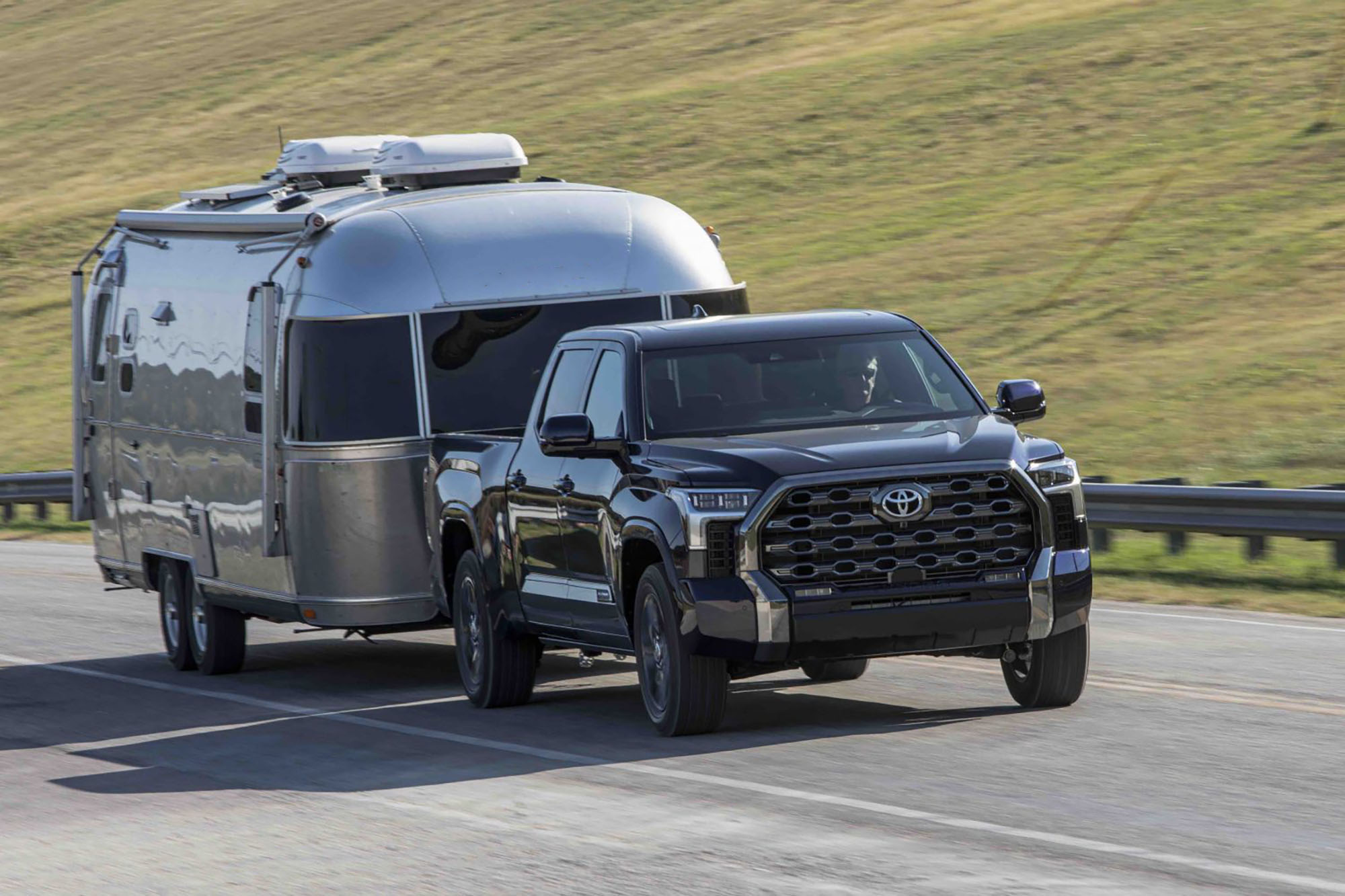 Black Toyota Tundra pulling a silver camper.