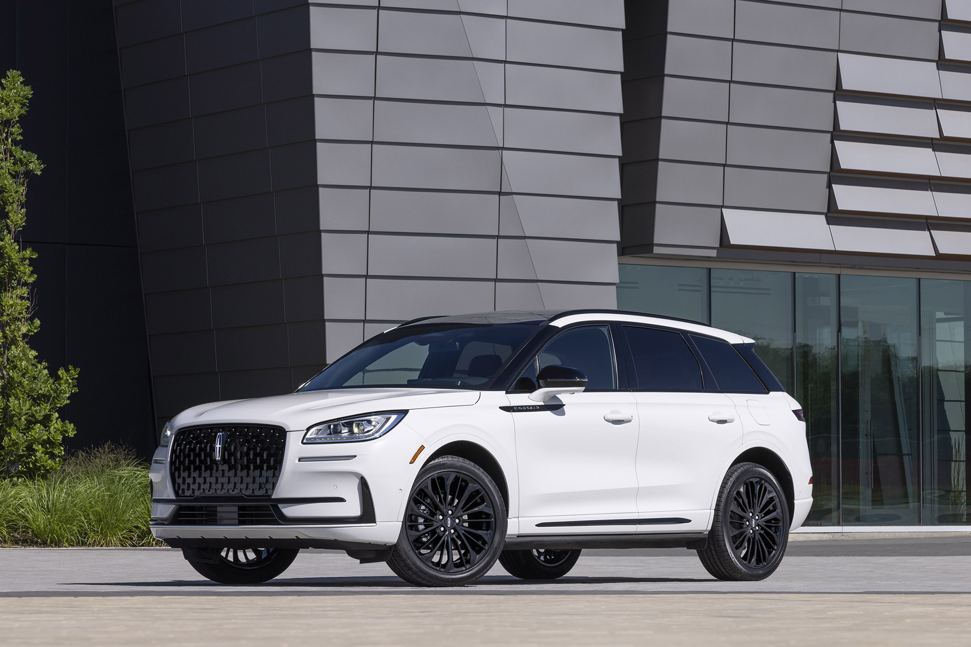 White Lincoln Corsair parked in front of a modern building.