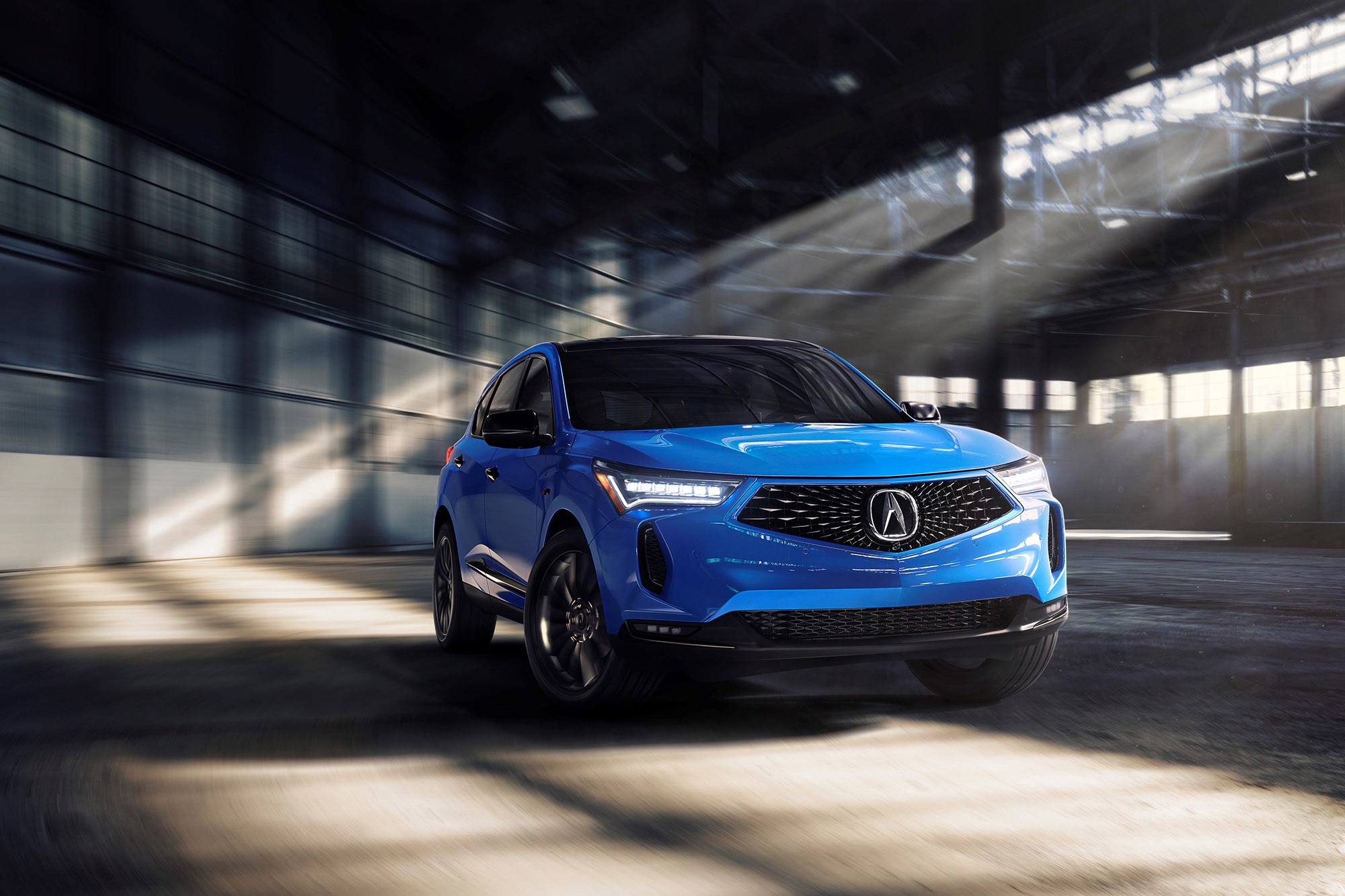 Blue Acura RDX driving through a warehouse environment.