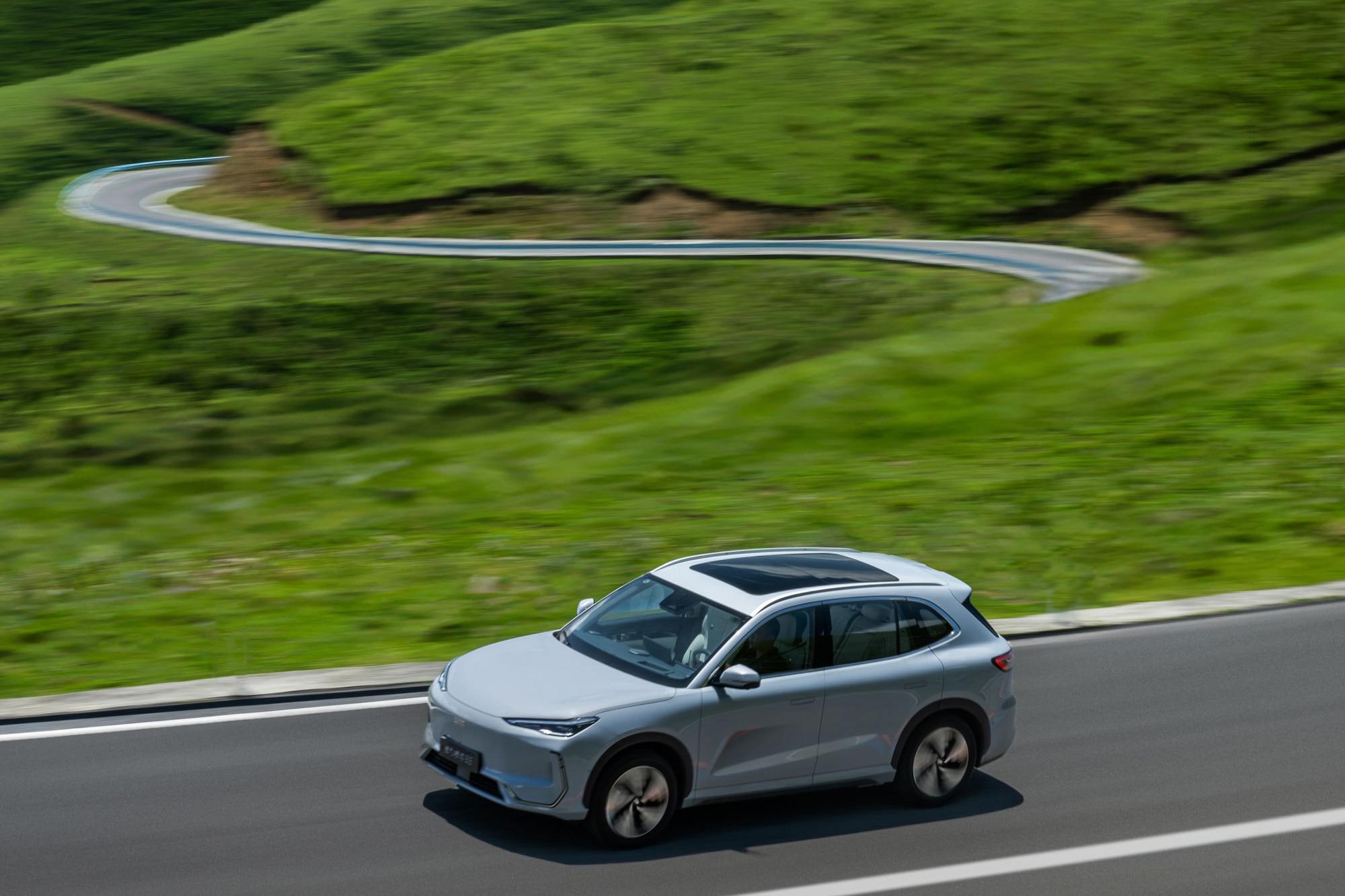 Geely E5 driving on a highway in the hills