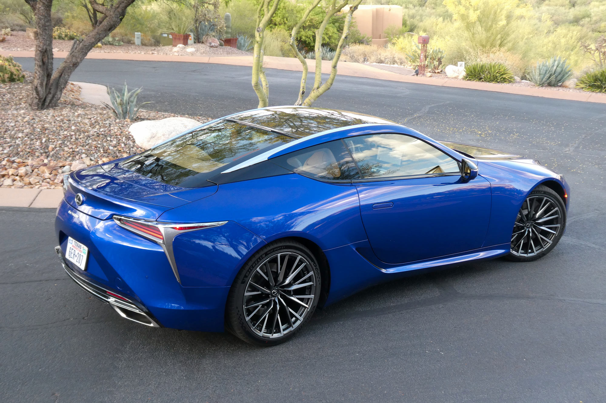 Rear-quarter of a blue 2024 Lexus LC 500h parked in a neighborhood