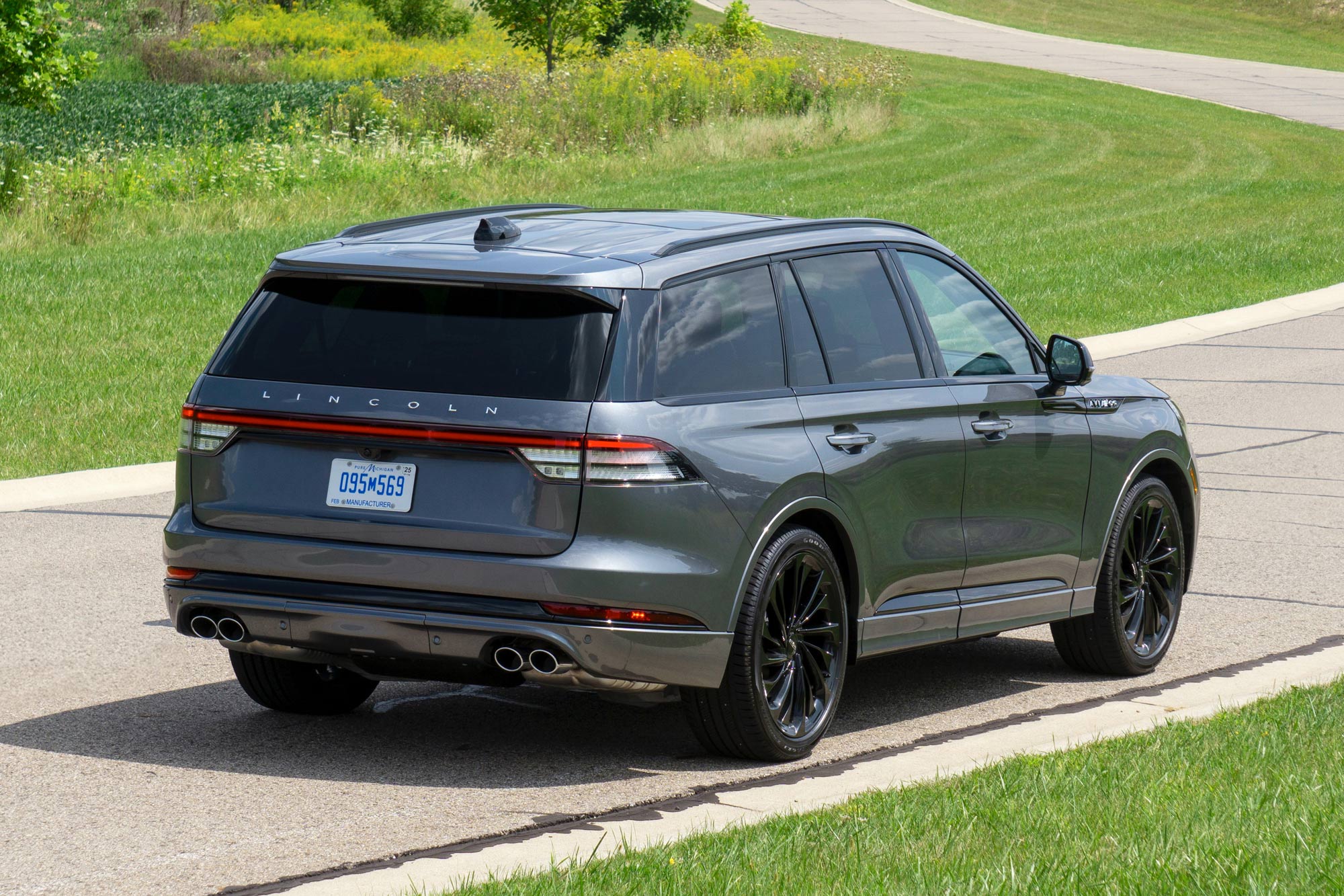 2025 Lincoln Aviator Reserve in Asher Gray with a field and a winding road in the background