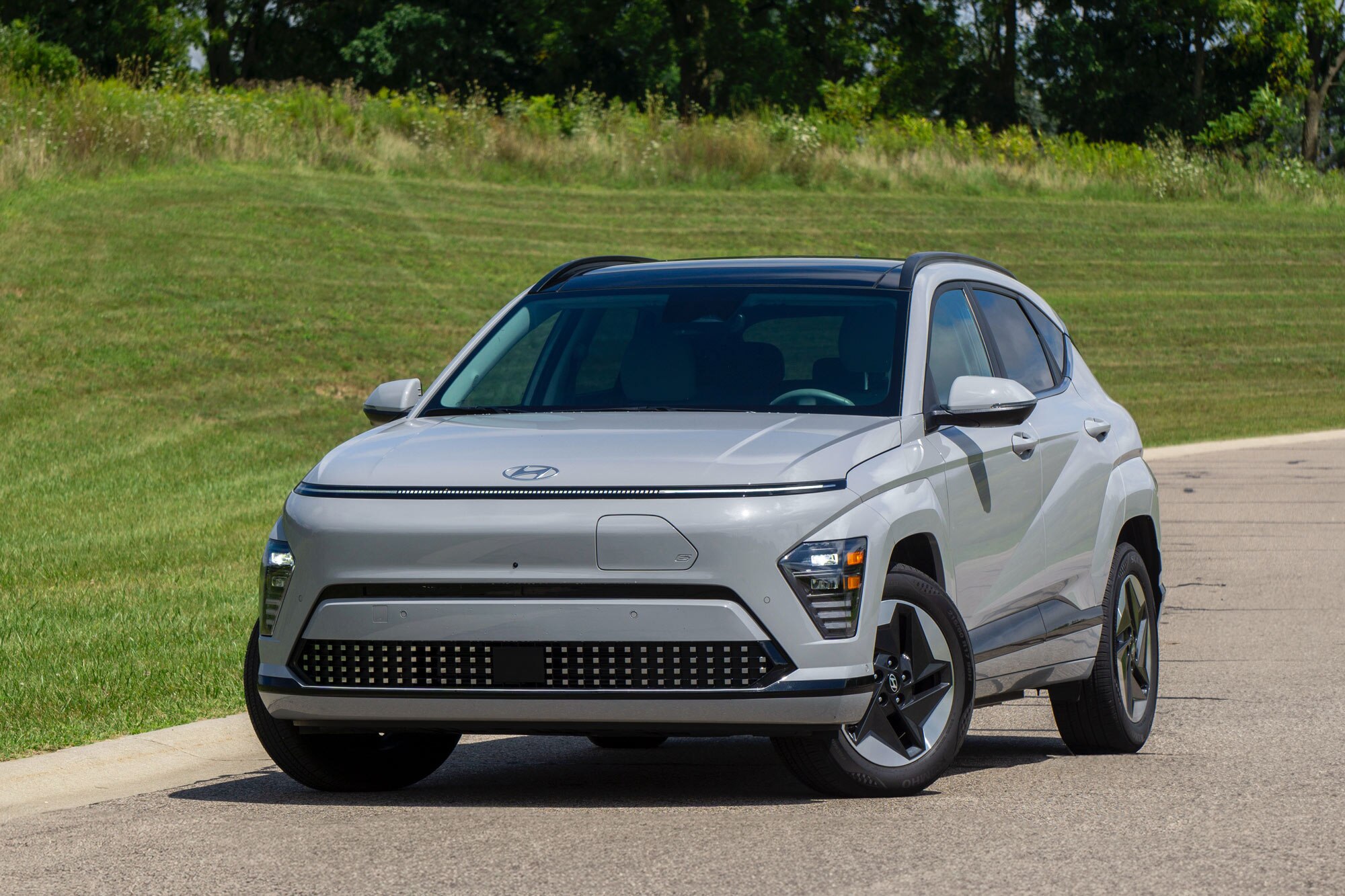 2024 Hyundai Kona Electric Limited in Cyber Gray with a grassy hill behind it