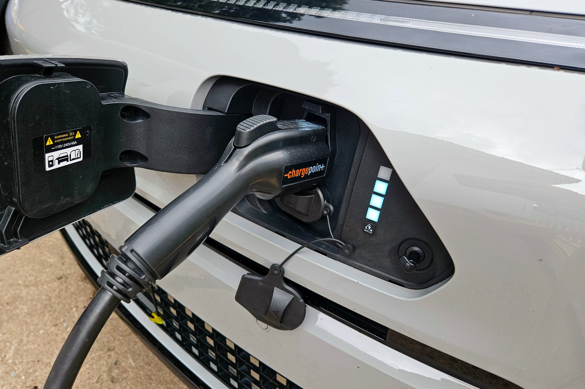 White 2024 Hyundai Kona Electric Limited shown plugged in