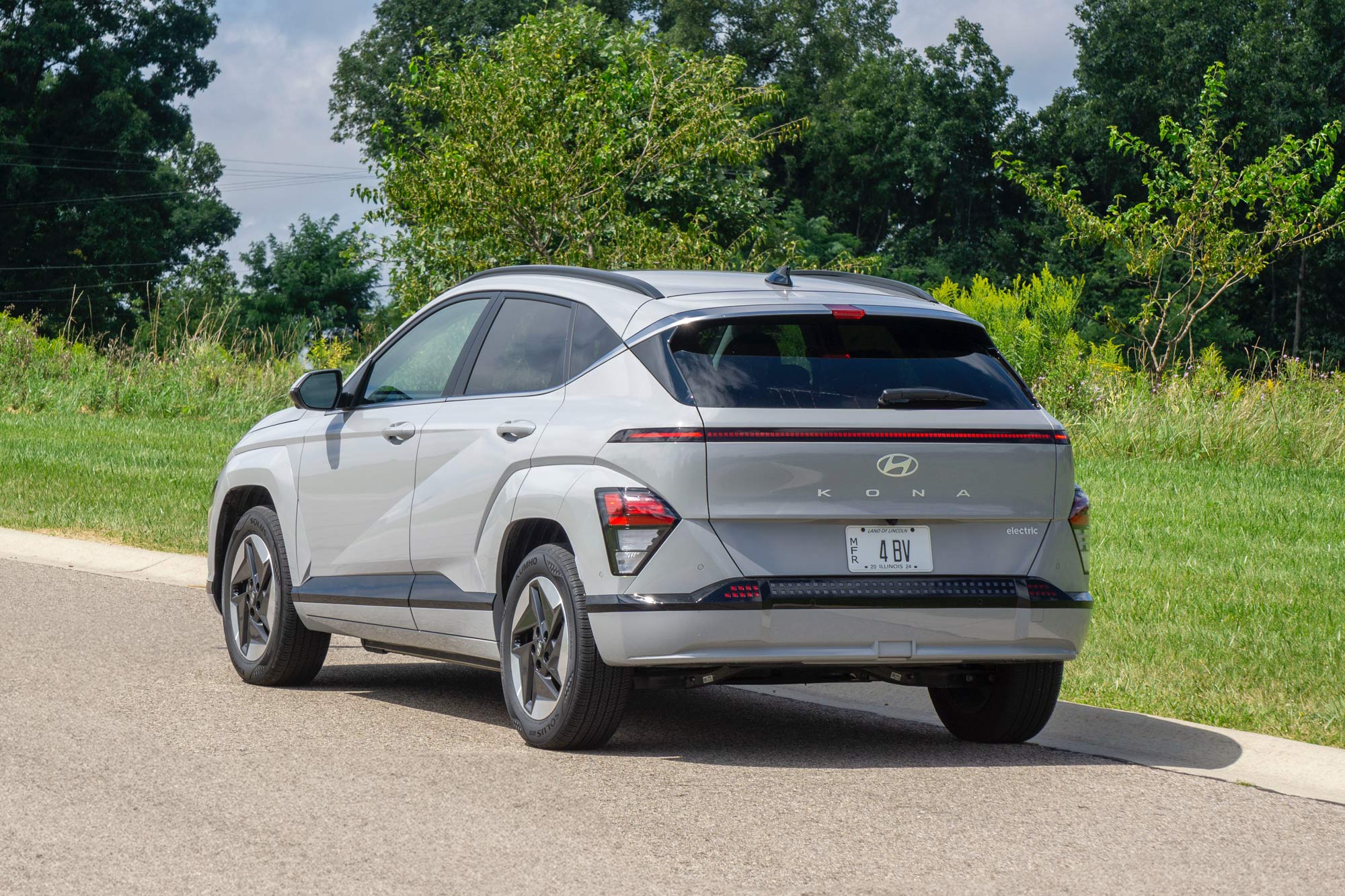 2024 Hyundai Kona Electric Limited in Cyber Gray with grass and trees behind it