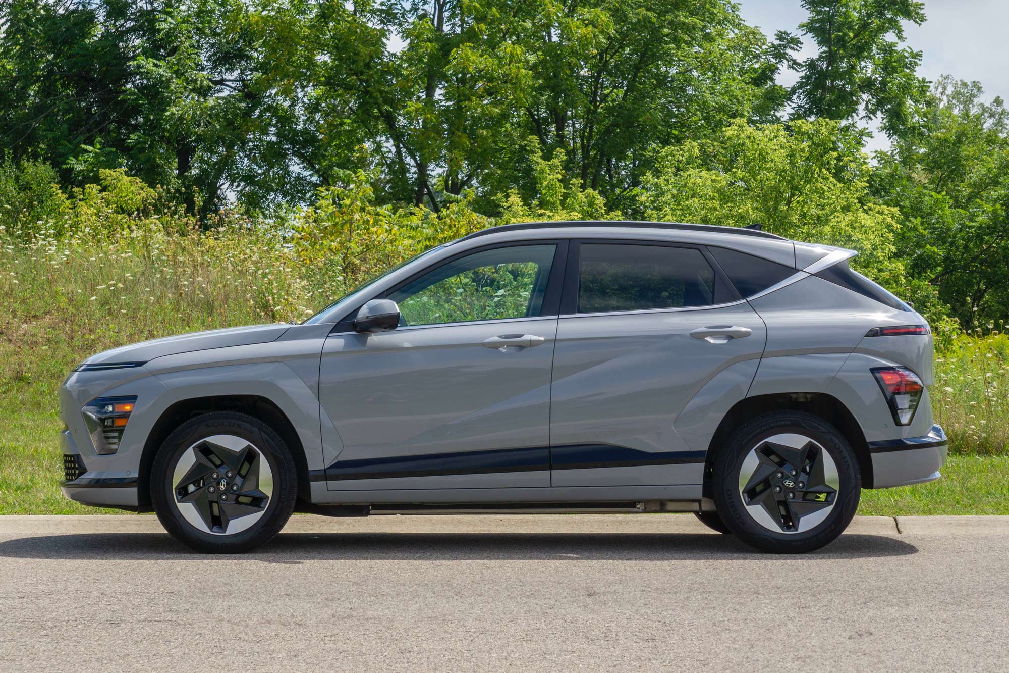 2024 Hyundai Kona Electric Limited in Cyber Gray with grass and trees behind it