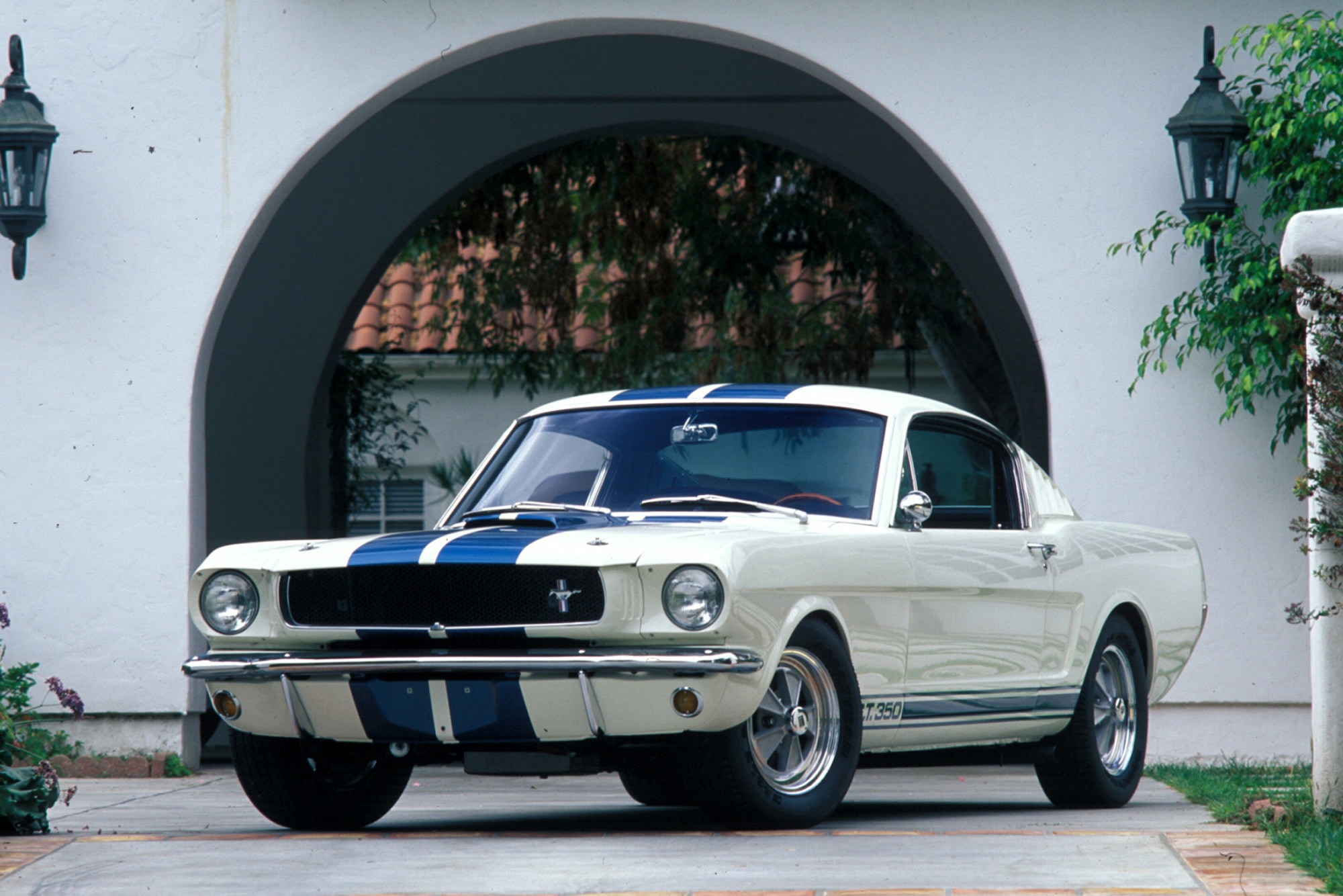 A white 1965 Shelby Mustang GT350 with blue racing stripes