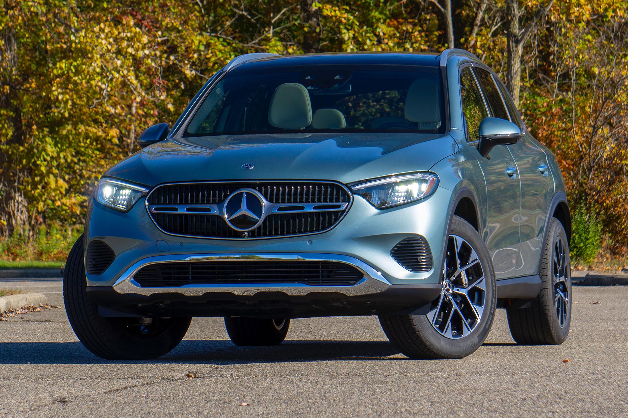 2025 Mercedes-Benz GLC 350e plug-in hybrid in Verde Silver with trees in background.