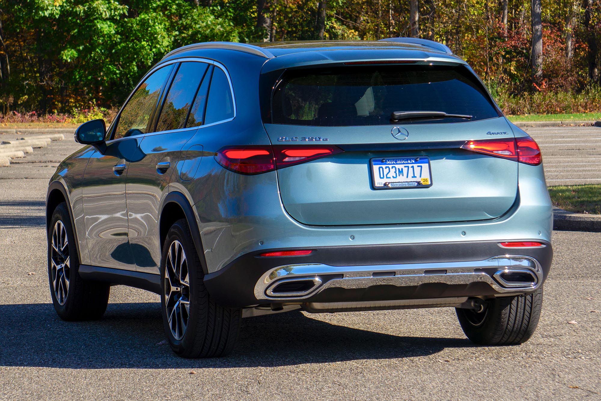 2025 Mercedes-Benz GLC 350e plug-in hybrid in Verde Silver with trees in background.