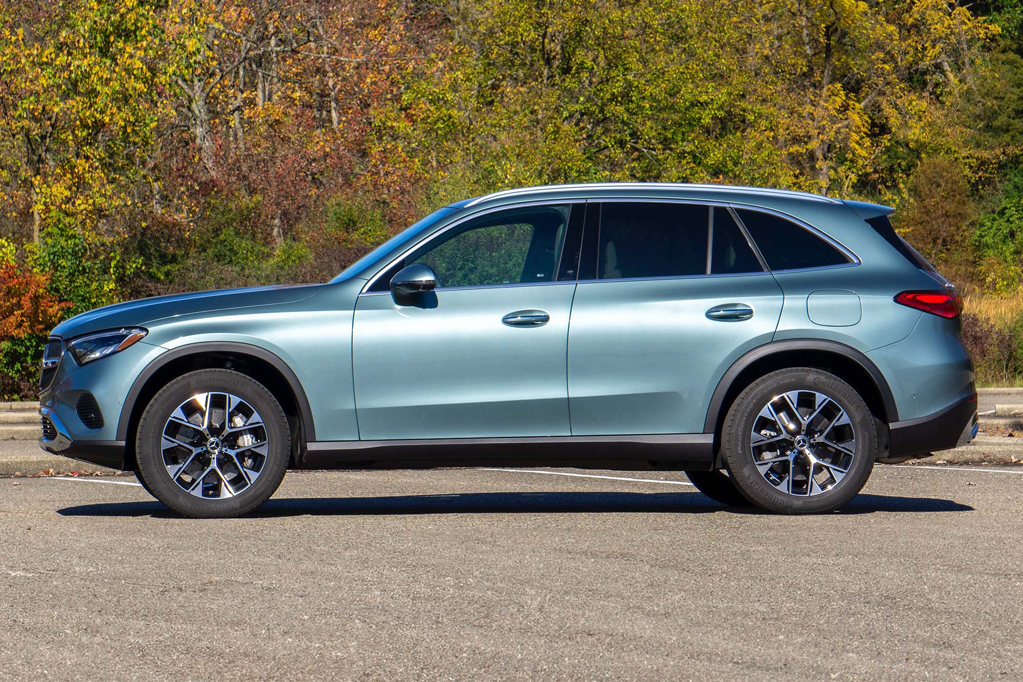 2025 Mercedes-Benz GLC 350e plug-in hybrid in Verde Silver with trees in the background.