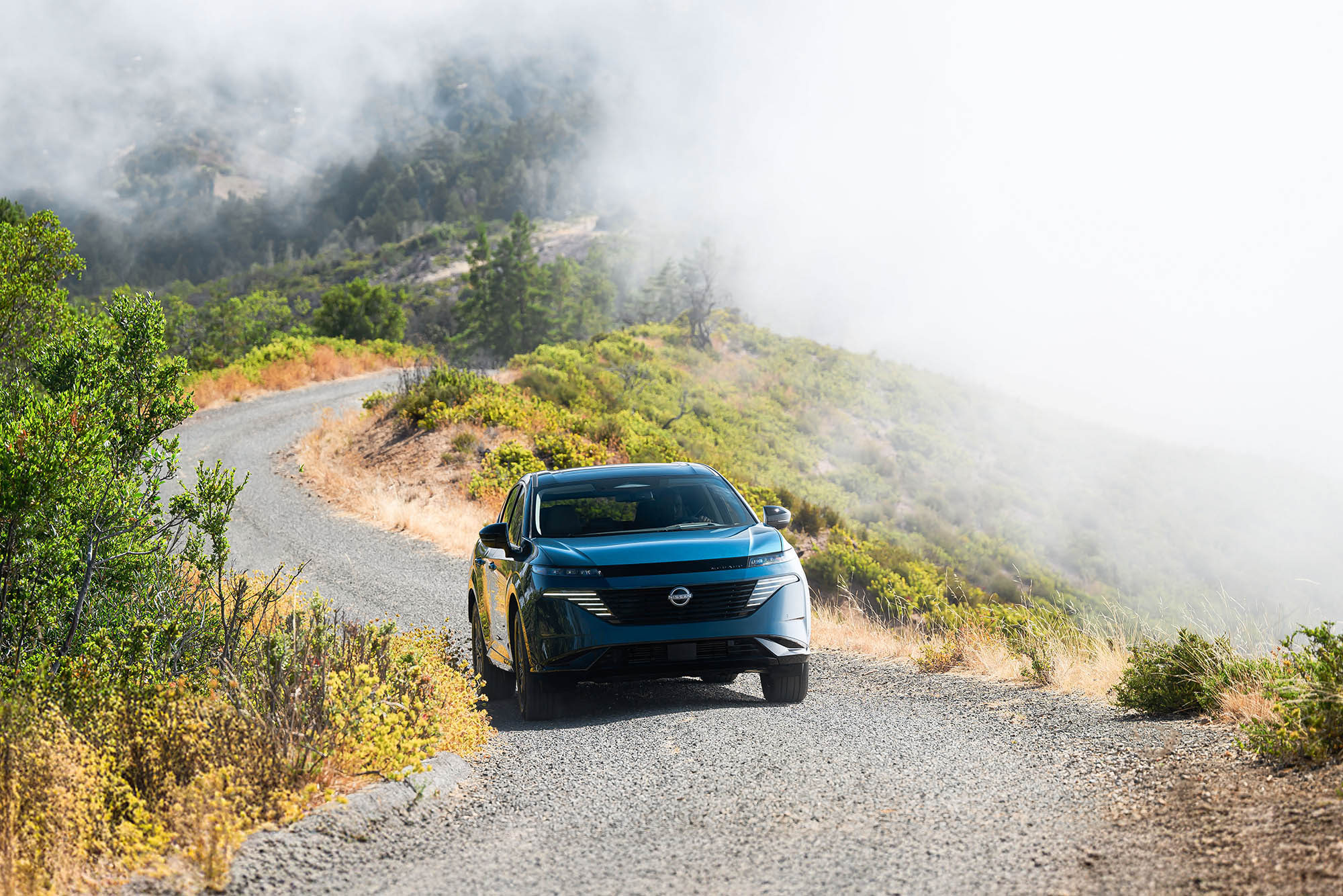 2025 Nissan Murano in blue driving away from coastal fog