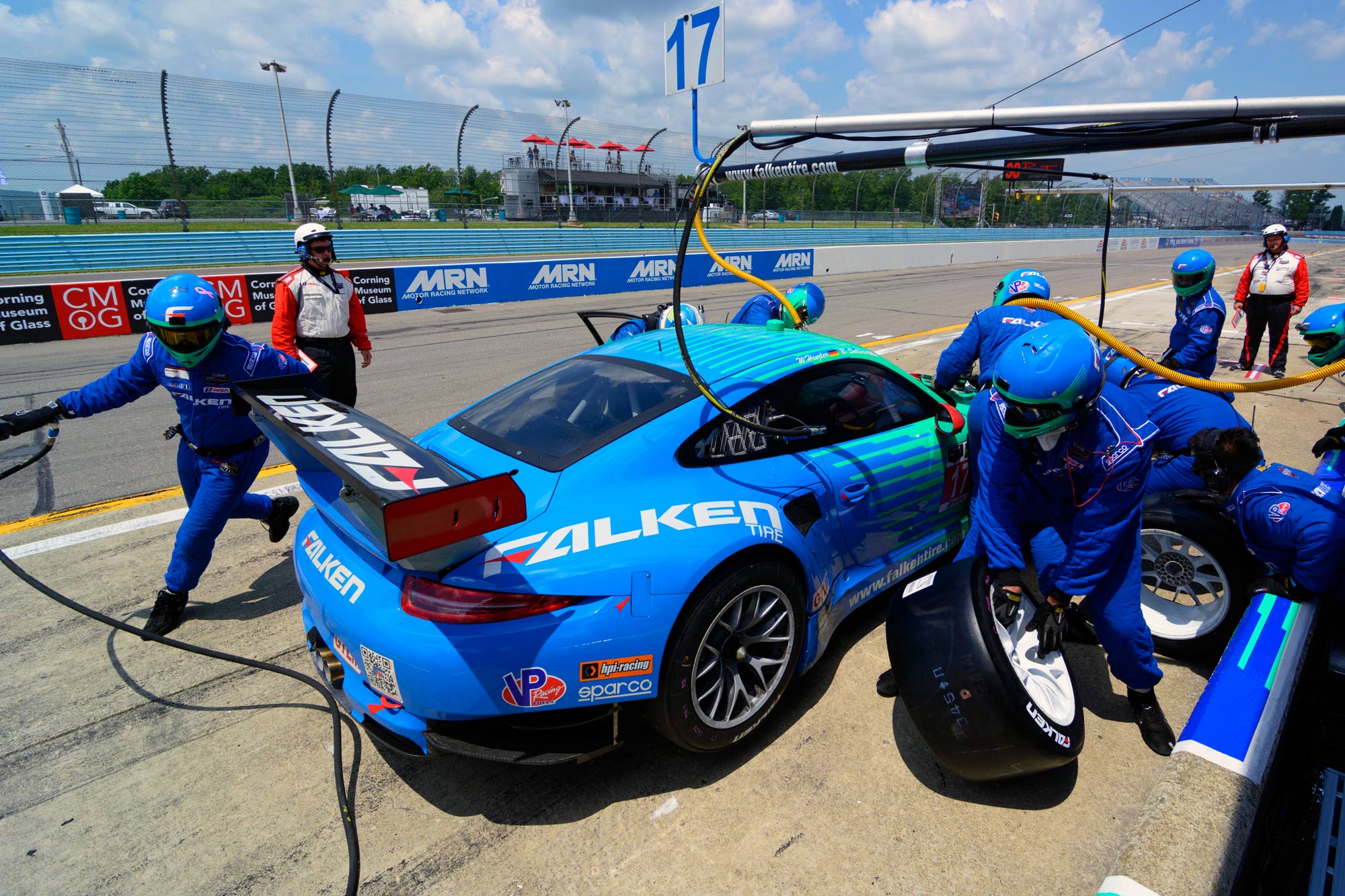 A blue Porsche 911 RSR getting a tire change in pit lane