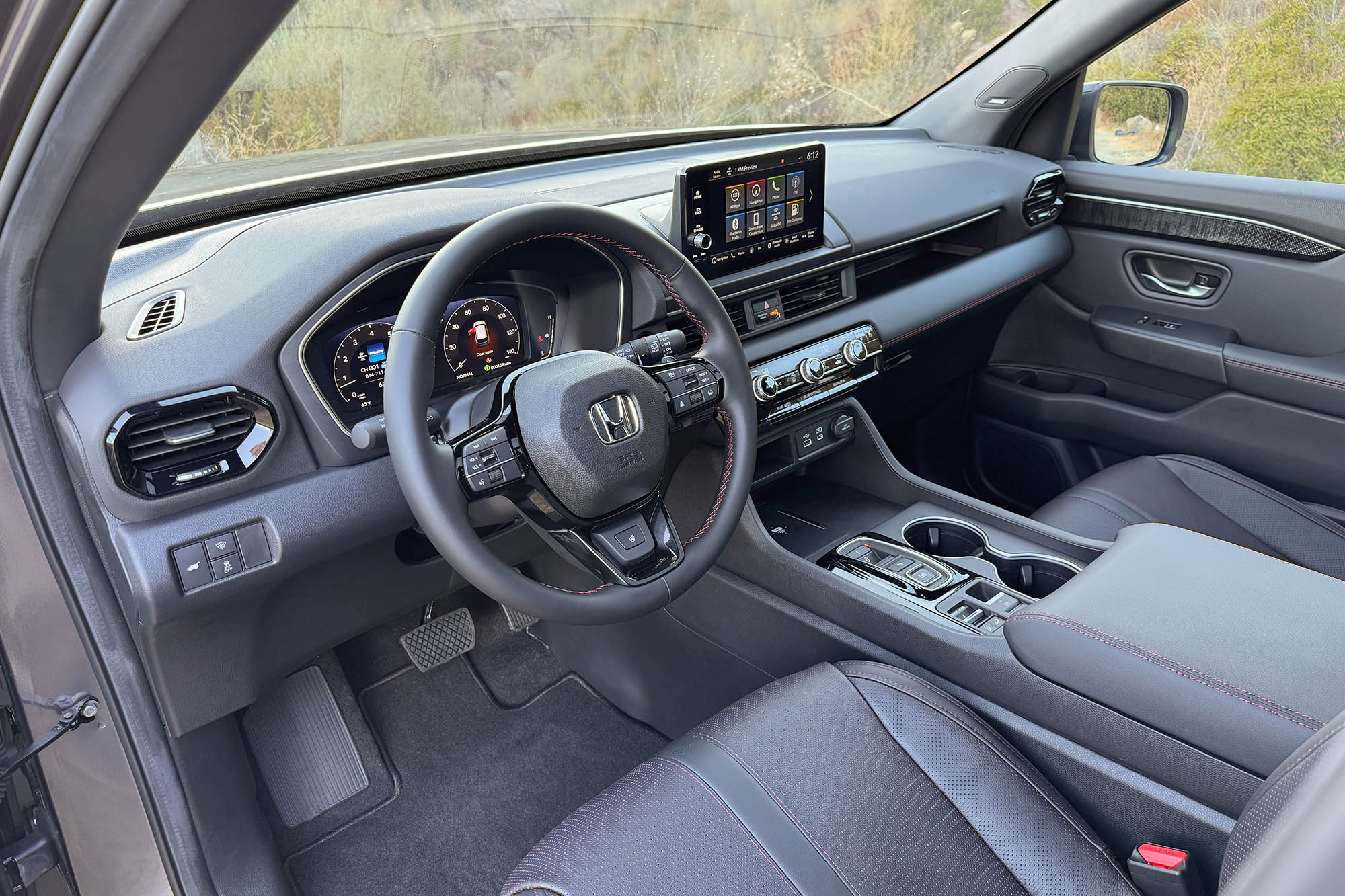 2025 Honda Pilot Black Edition interior showing the dashboard and front seats.