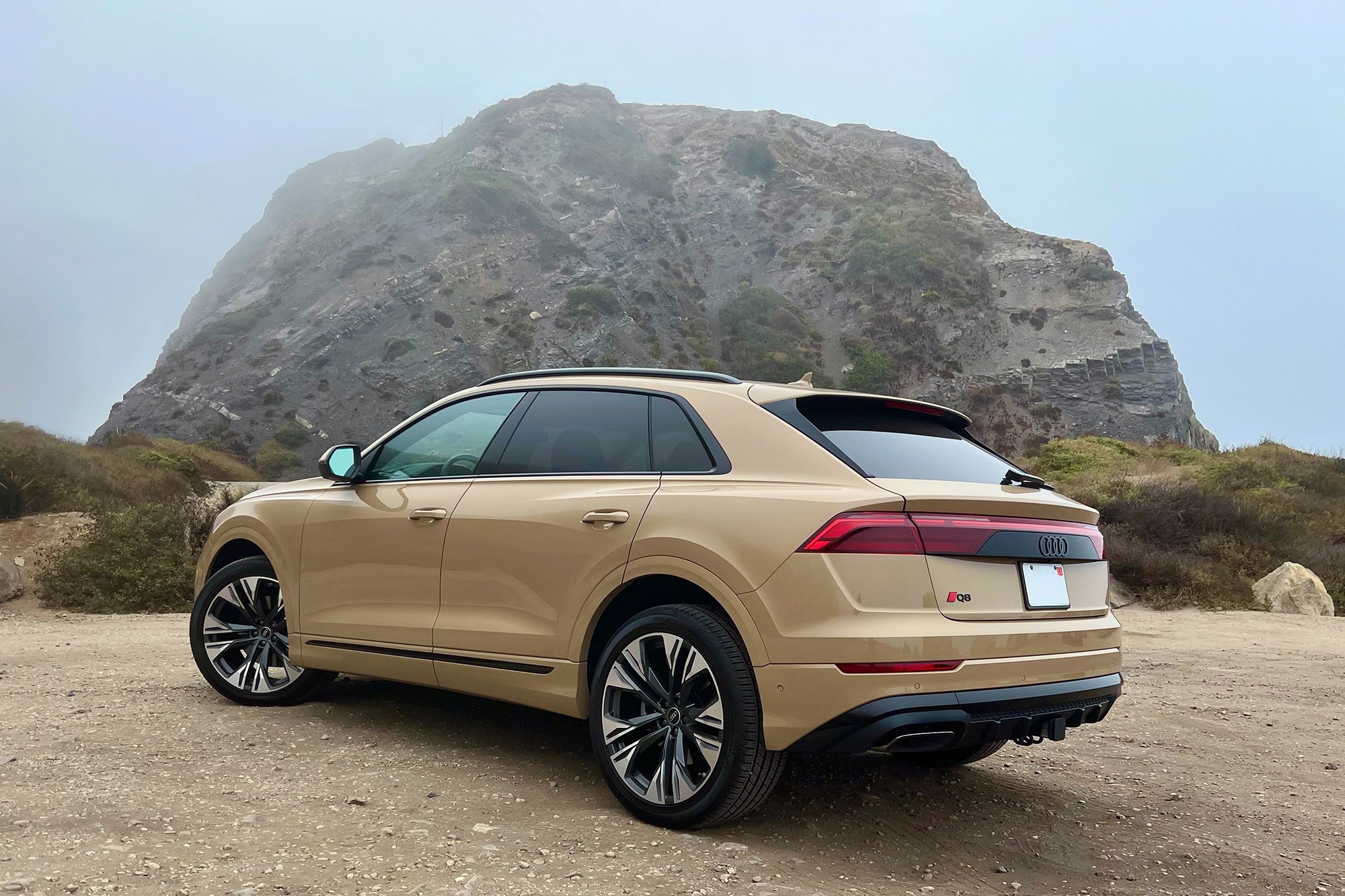 2025 Audi Q8 Prestige in Sakhir Gold Metallic with a rock formation in the background.