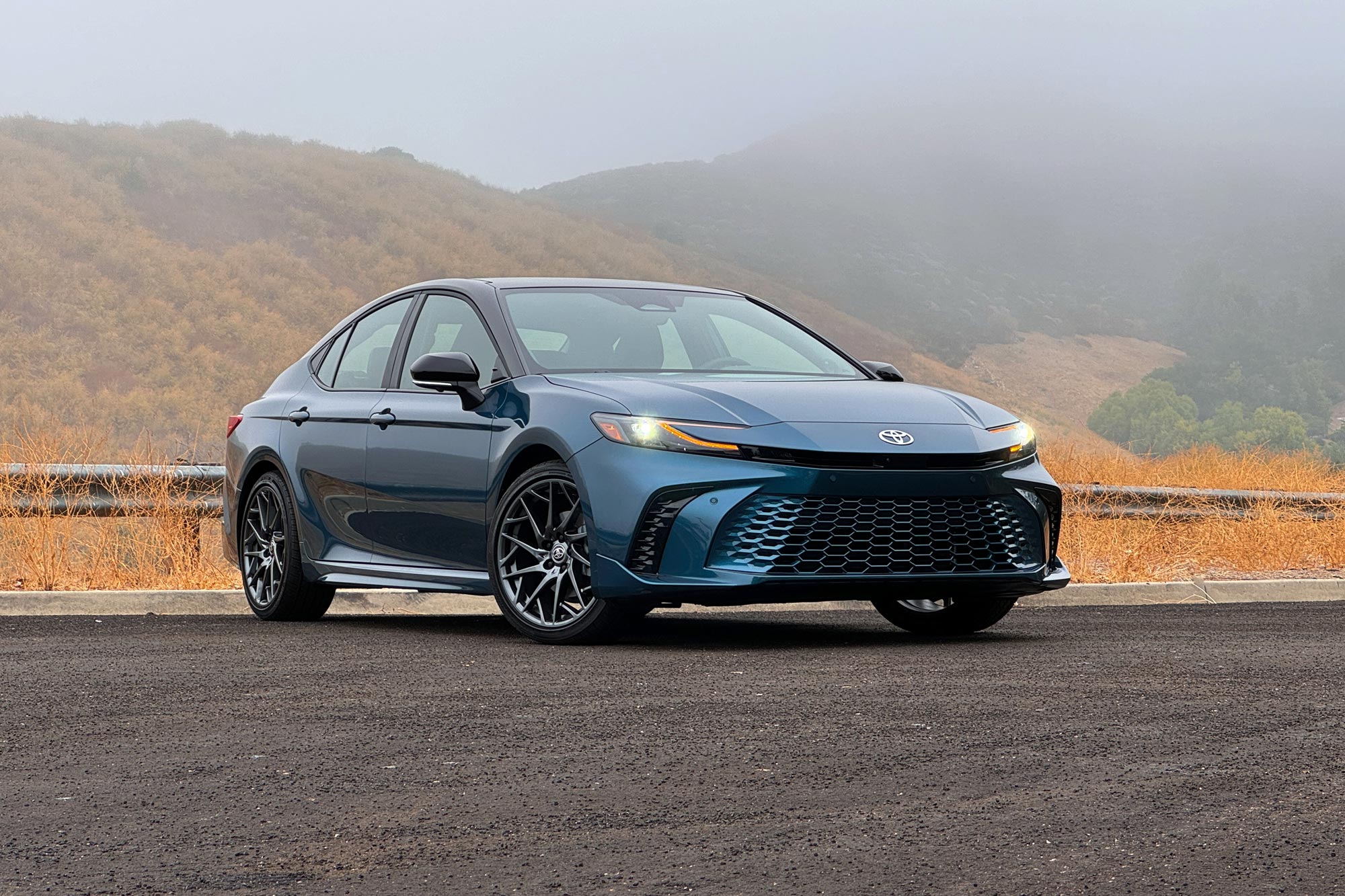 2025 Toyota Camry XSE in Ocean Gem with dry brush and foggy mountains in the background.