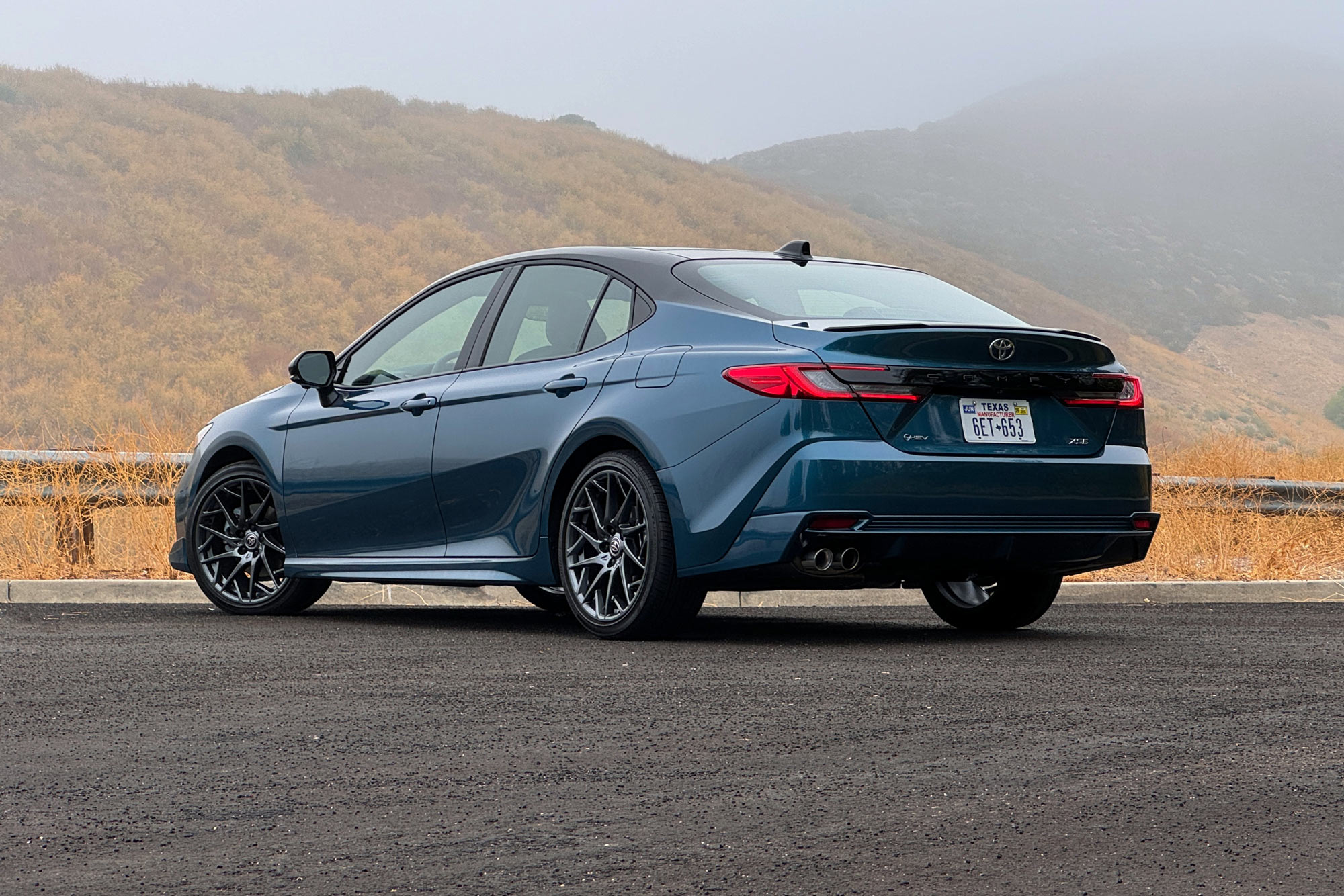 2025 Toyota Camry XSE in Ocean Gem with dry brush and foggy mountains in the background.