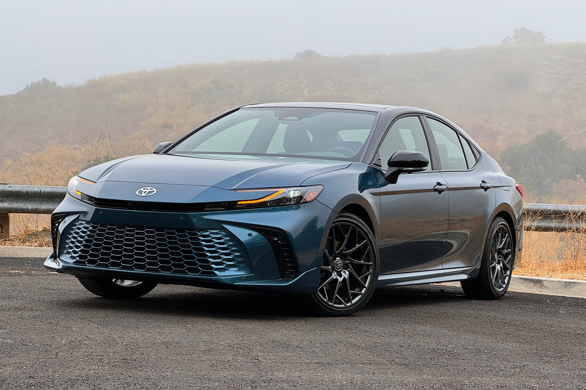 2025 Toyota Camry XSE in Ocean Gem with dry brush and a foggy hill in the background.