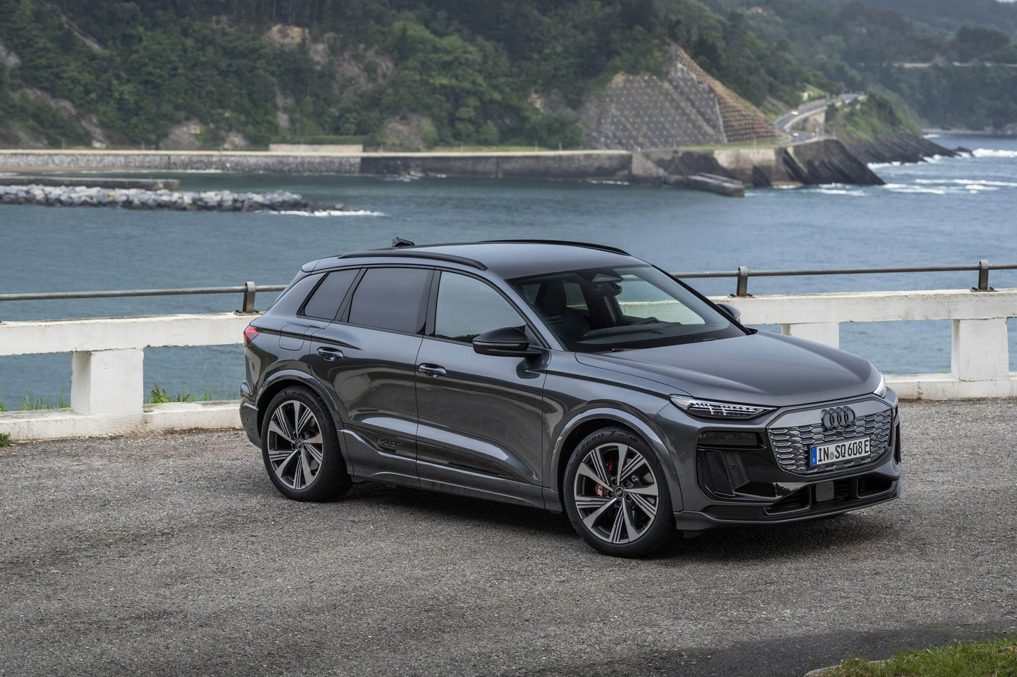 Front-right view of a 2025 Audi Q6 e-tron on a coastline.