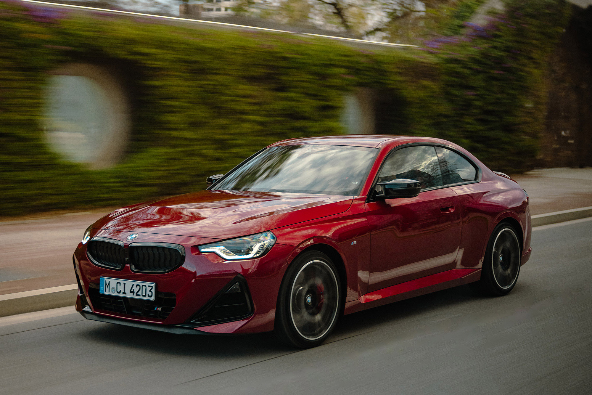 2025 BMW M240i xDrive in Vegas Red Metallic, driving