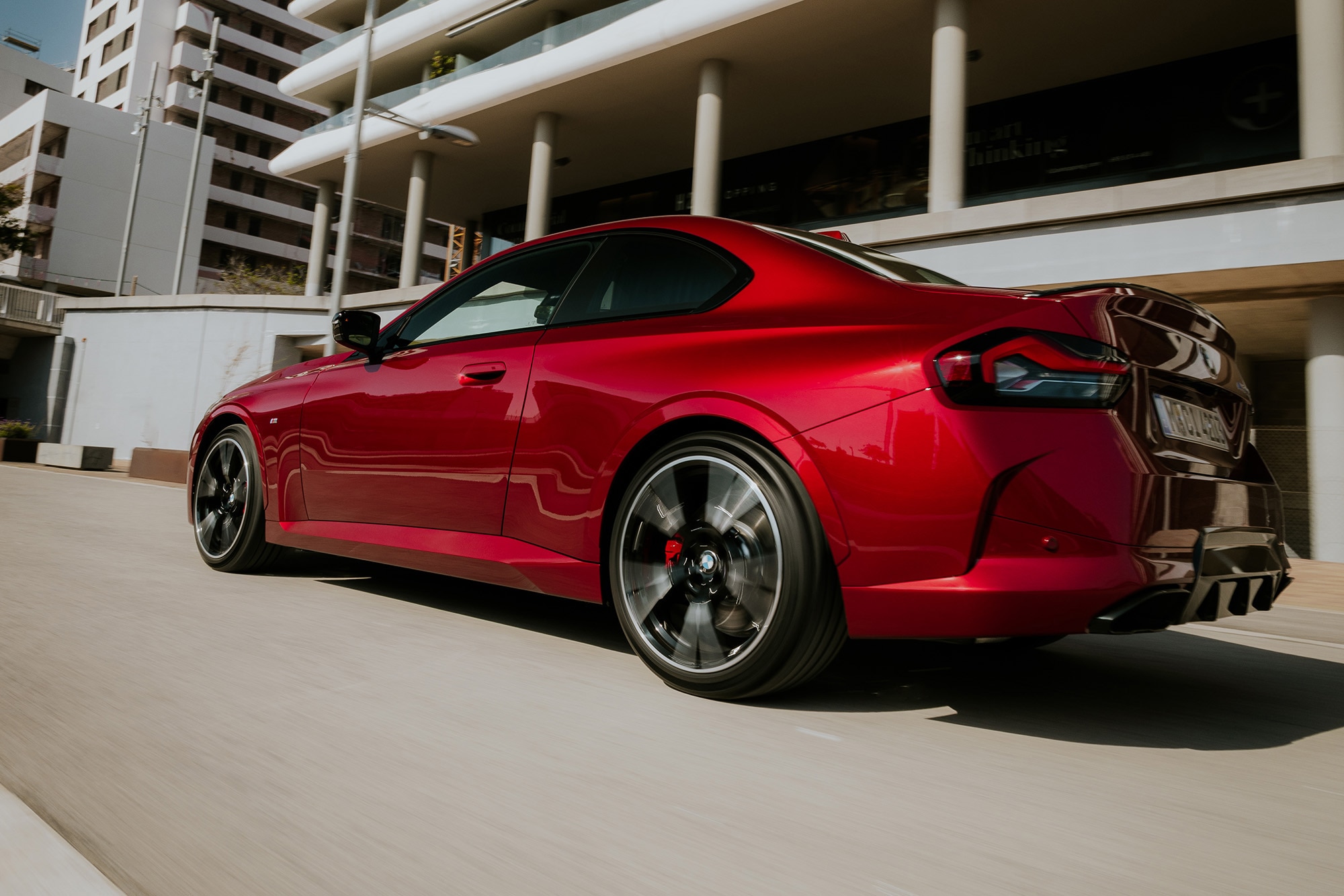 2025 BMW M240i xDrive in Vegas Red Metallic, rear view, driving