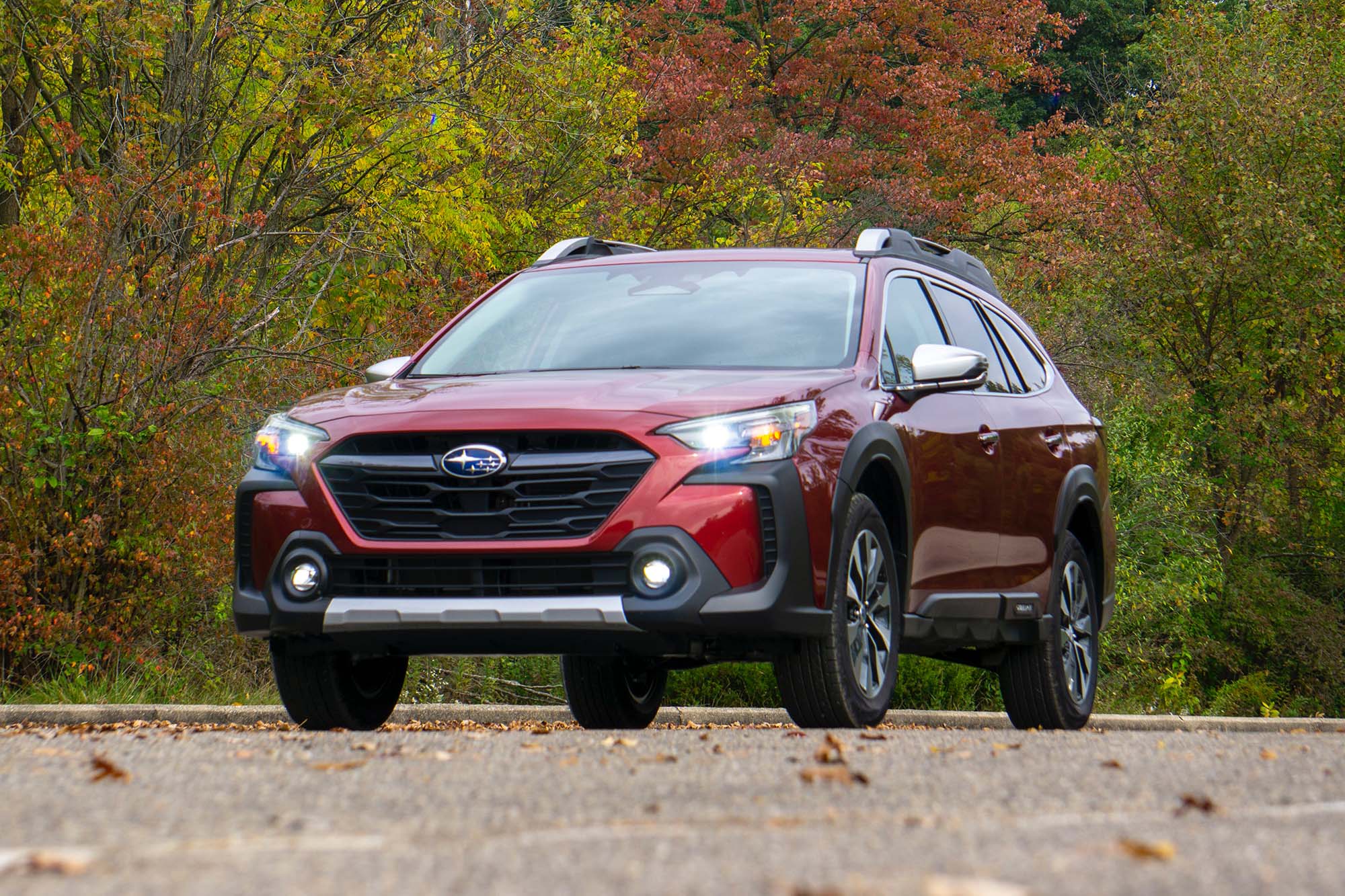 2025 Subaru Outback Touring XT in Crimson Red Pearl with background trees showing fall colors