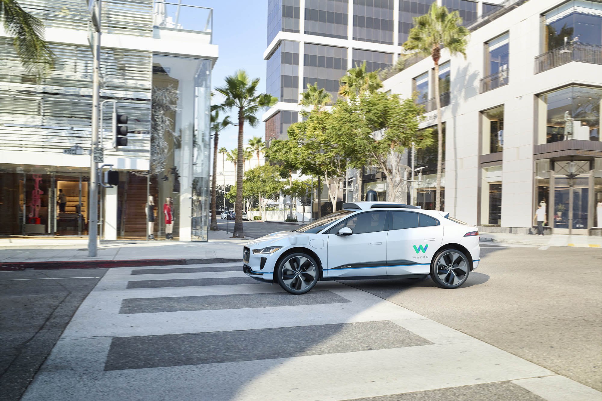 White Jaguar I-Pace being used as a Waymo One robo-taxi drives on Rodeo Drive in Beverly Hills, California