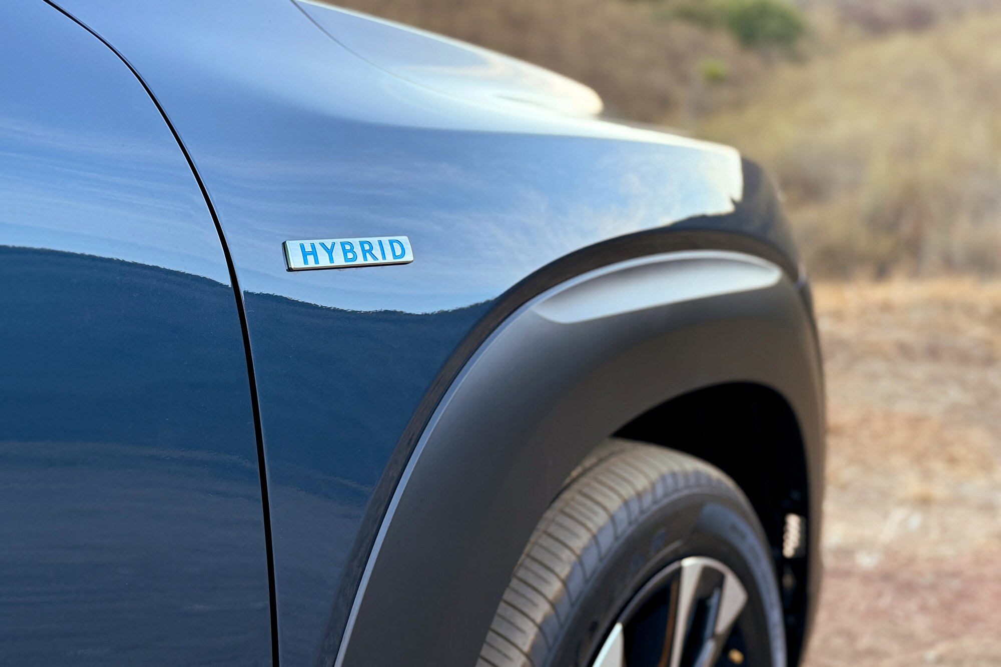 The hybrid badge on an Ingot Blue 2025 Mazda CX-50 Hybrid Premium Plus