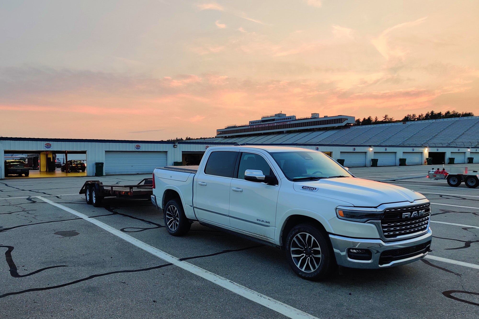 A white 2025 Ram 1500 towing an empty trailer