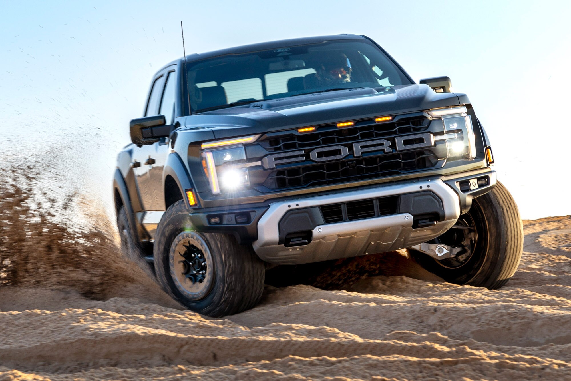 A blue 2024 Ford F-150 Raptor in the sand