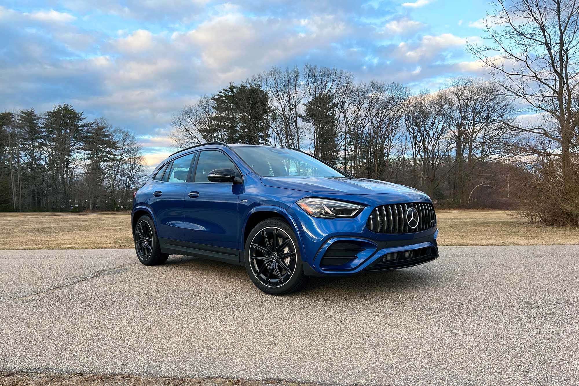 2024 Mercedes-AMG GLA 35 in Starling Blue Metallic with a field and trees in the background