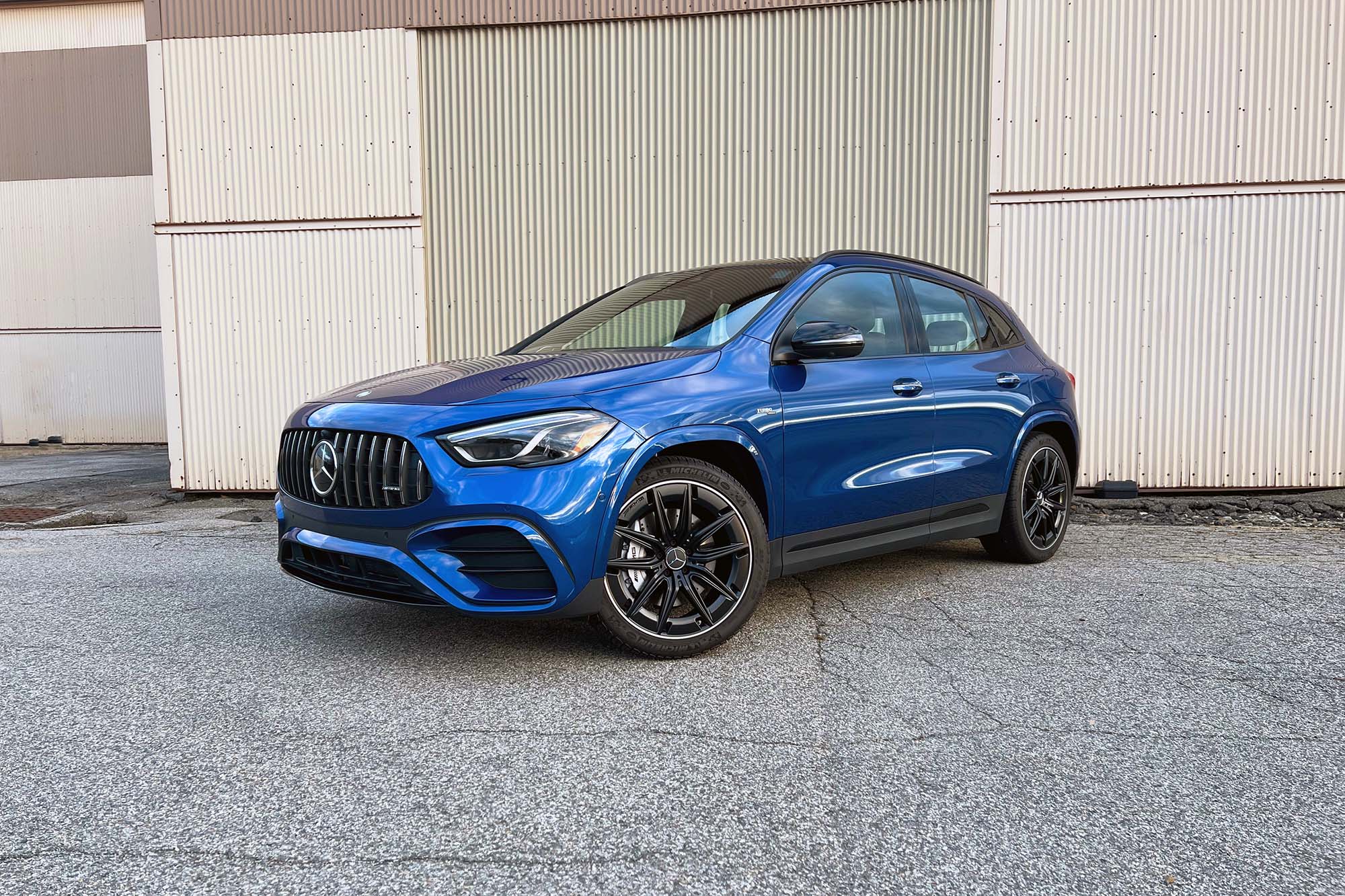 2024 Mercedes-AMG GLA 35 in Starling Blue Metallic parked in front of a warehouse