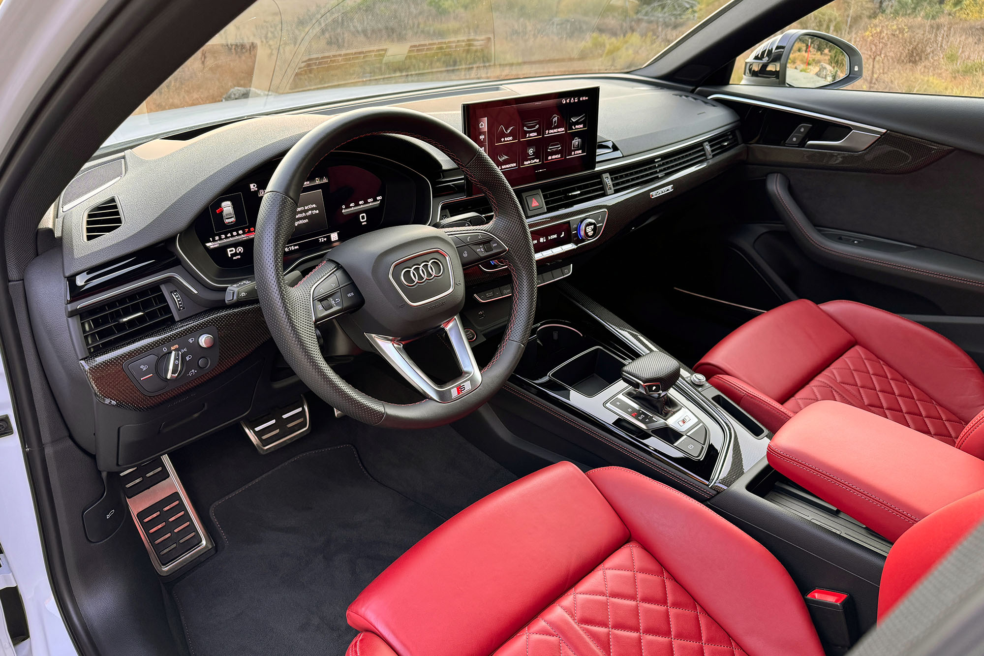 2025 Audi S4 interior showing the dashboard and Magma Red leather front seats.