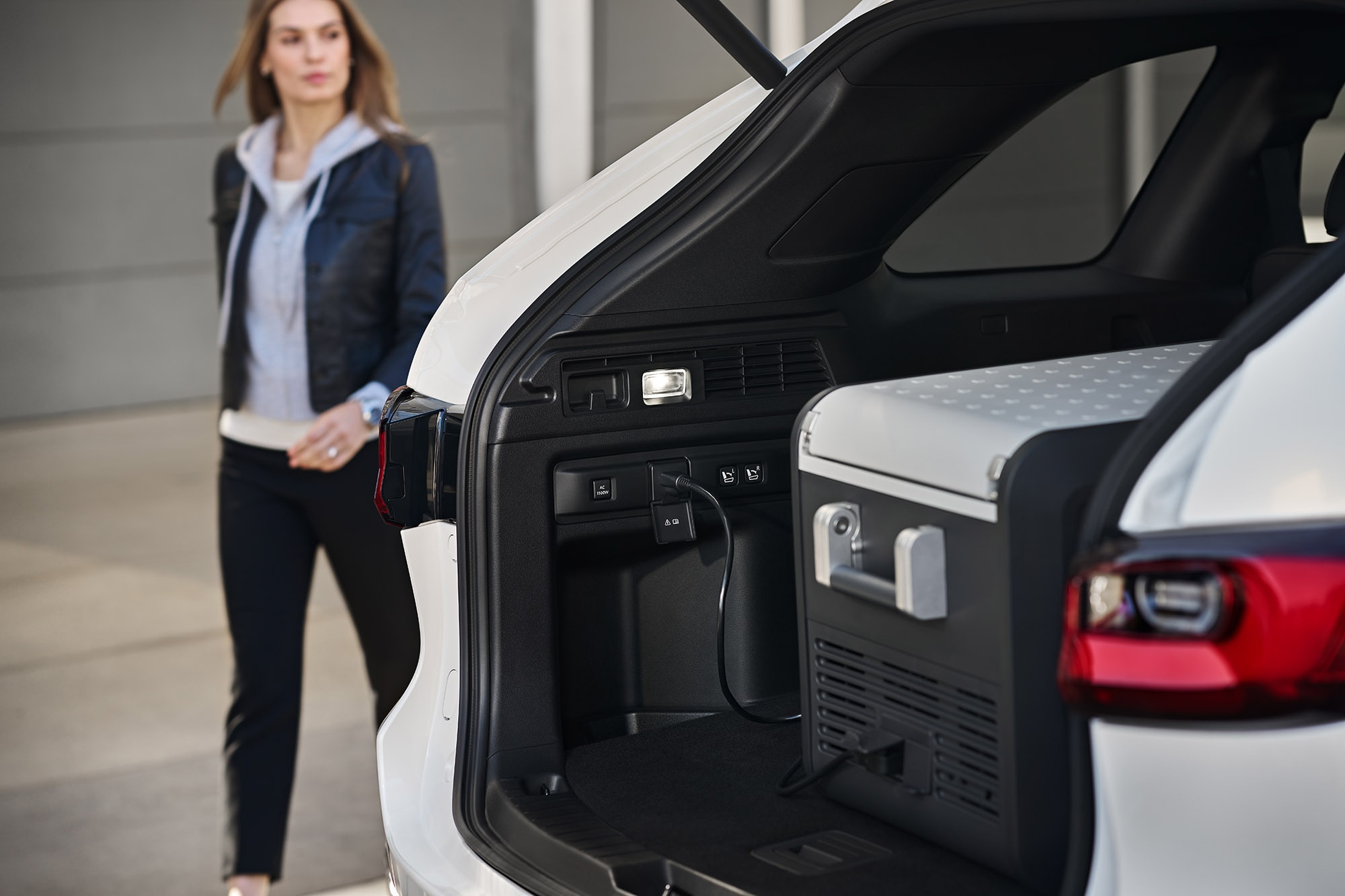 Open liftgate view of 2025 Mazda CX-70's cargo space with a device plugged in