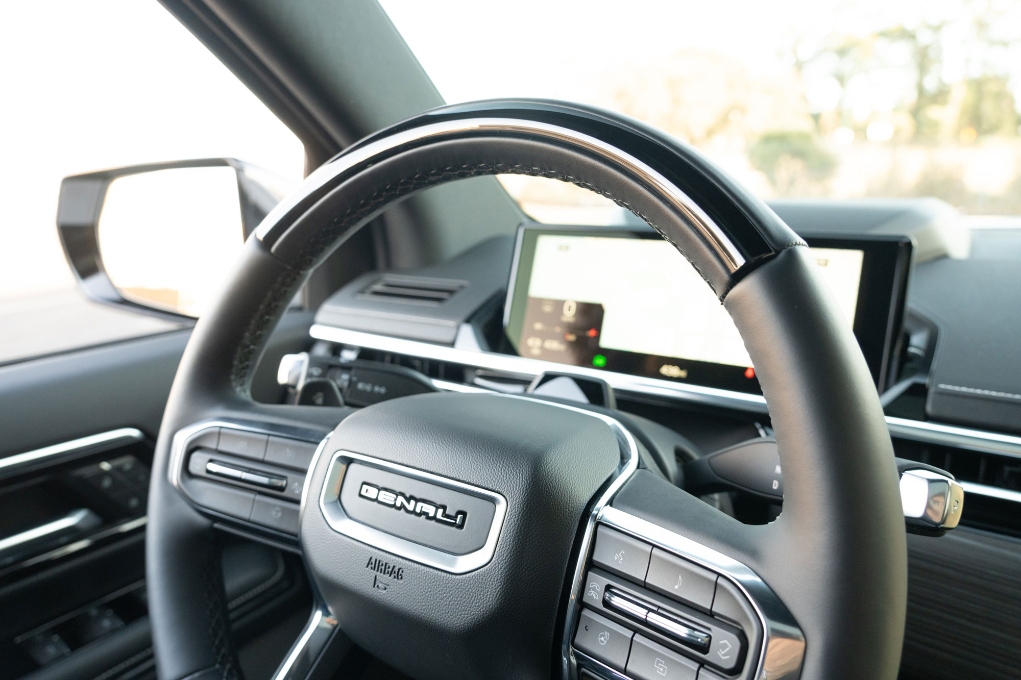 2025 GMC Sierra EV Denali interior showing the steering wheel with the digital driver display in the background.