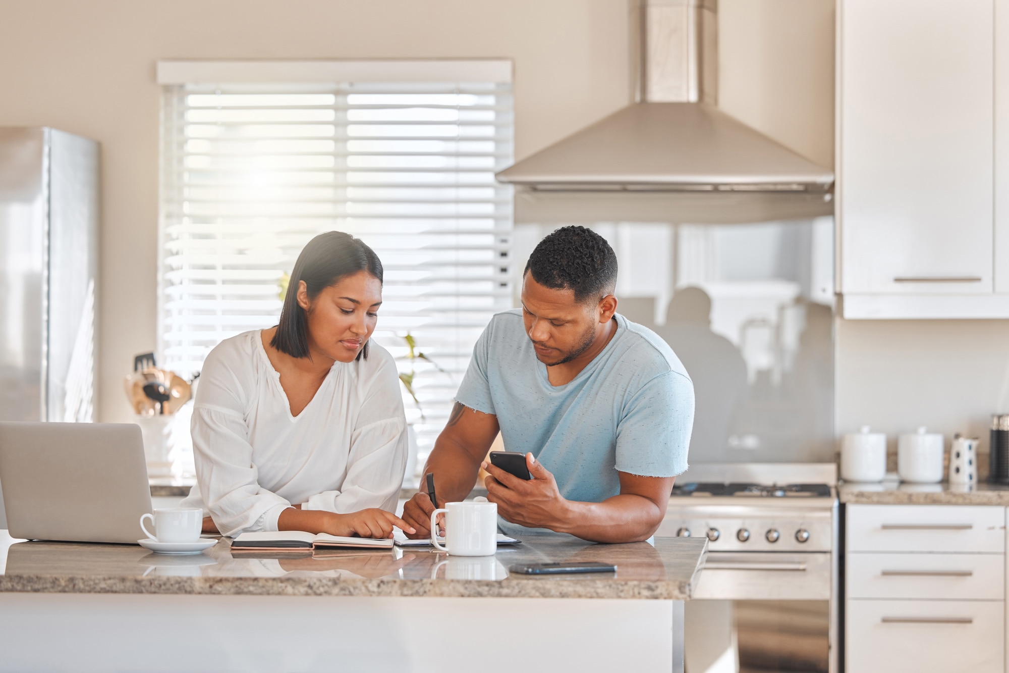 A couple going over paperwork together at kitchen island table