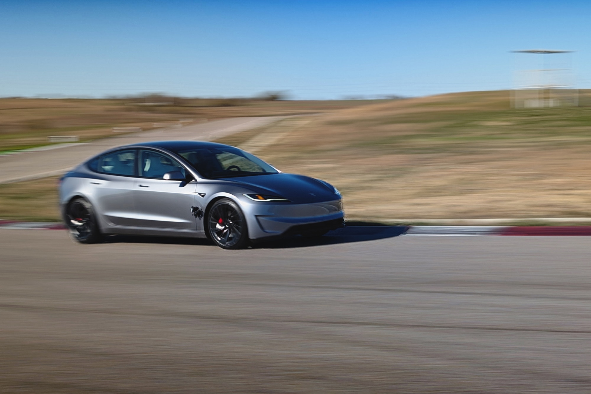 2025 Tesla Model 3 Performance in gray cornering at Eagles Canyon Raceway in Decatur Texas