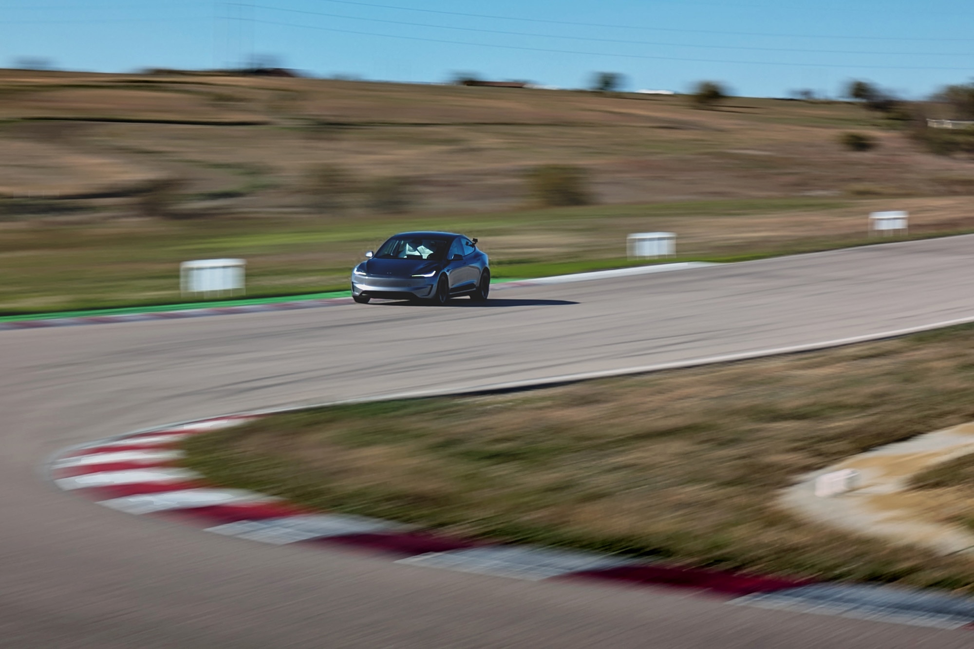 2025 Tesla Model 3 Performance in gray entering a corner at Eagles Canyon Raceway in Decatur Texas