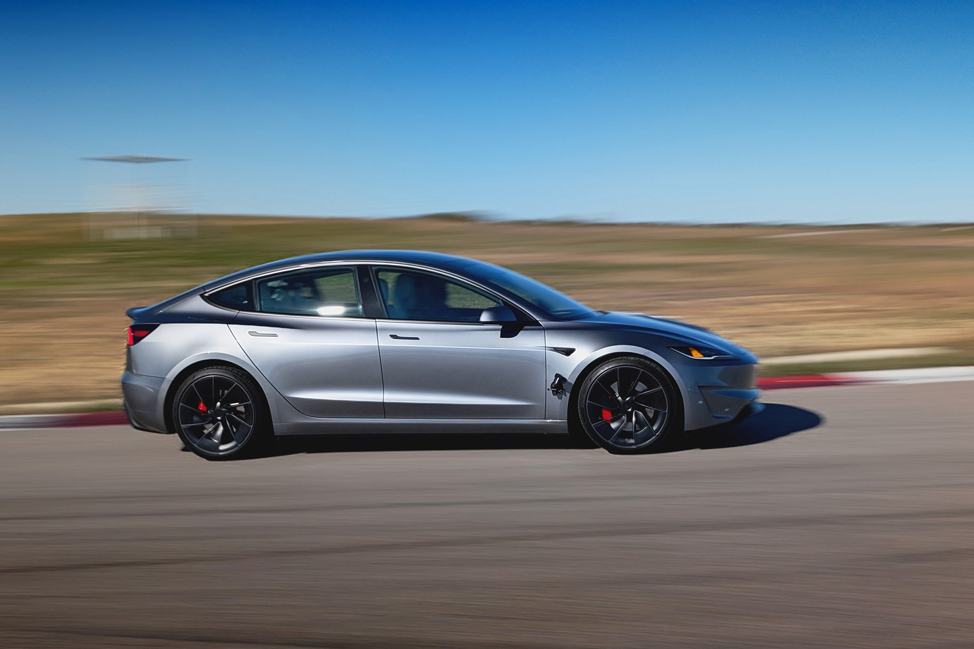 2025 Tesla Model 3 Performance in gray driving at Eagles Canyon Raceway in Decatur Texas