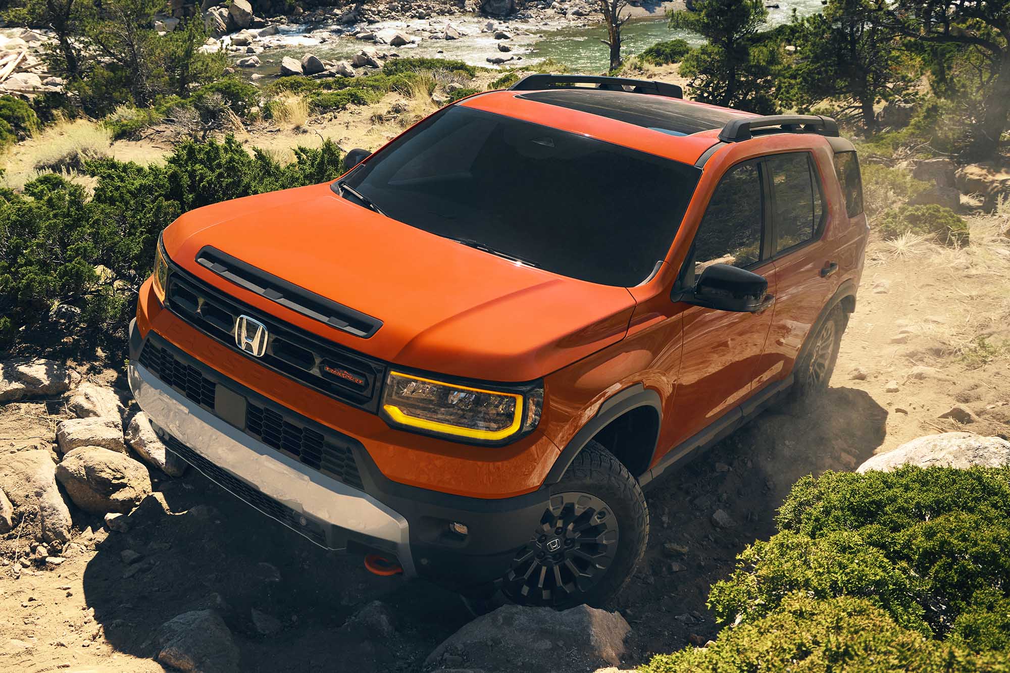 An orange 2026 Honda Passport TrailSport driving off road