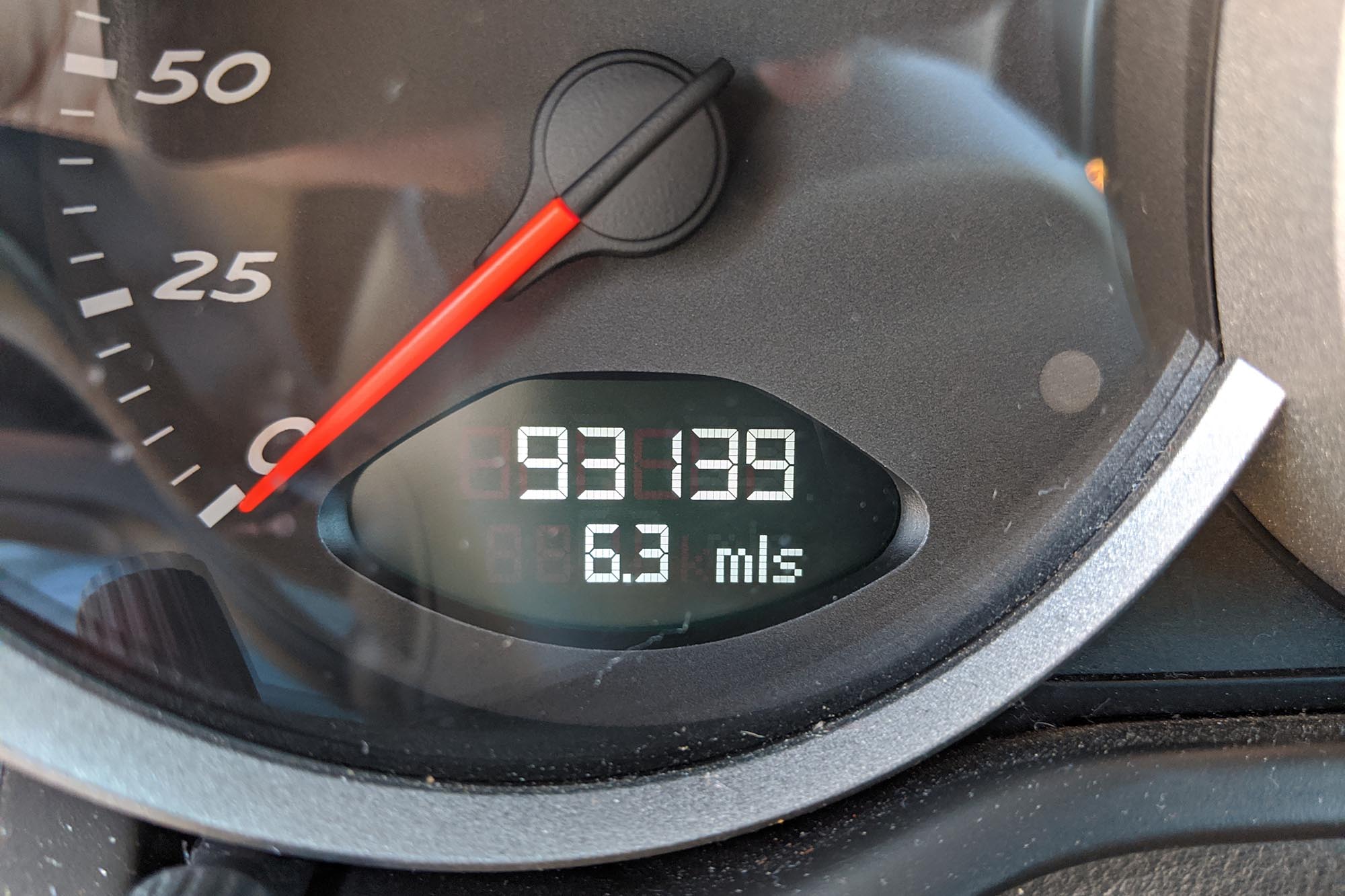 The odometer of a Porsche Cayman showing over 90,000 miles