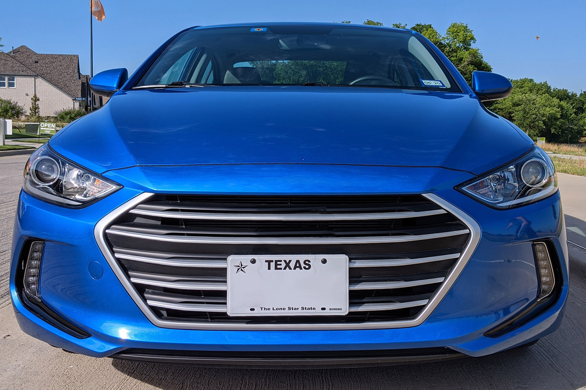 Front license plate from Texas affixed to a blue car