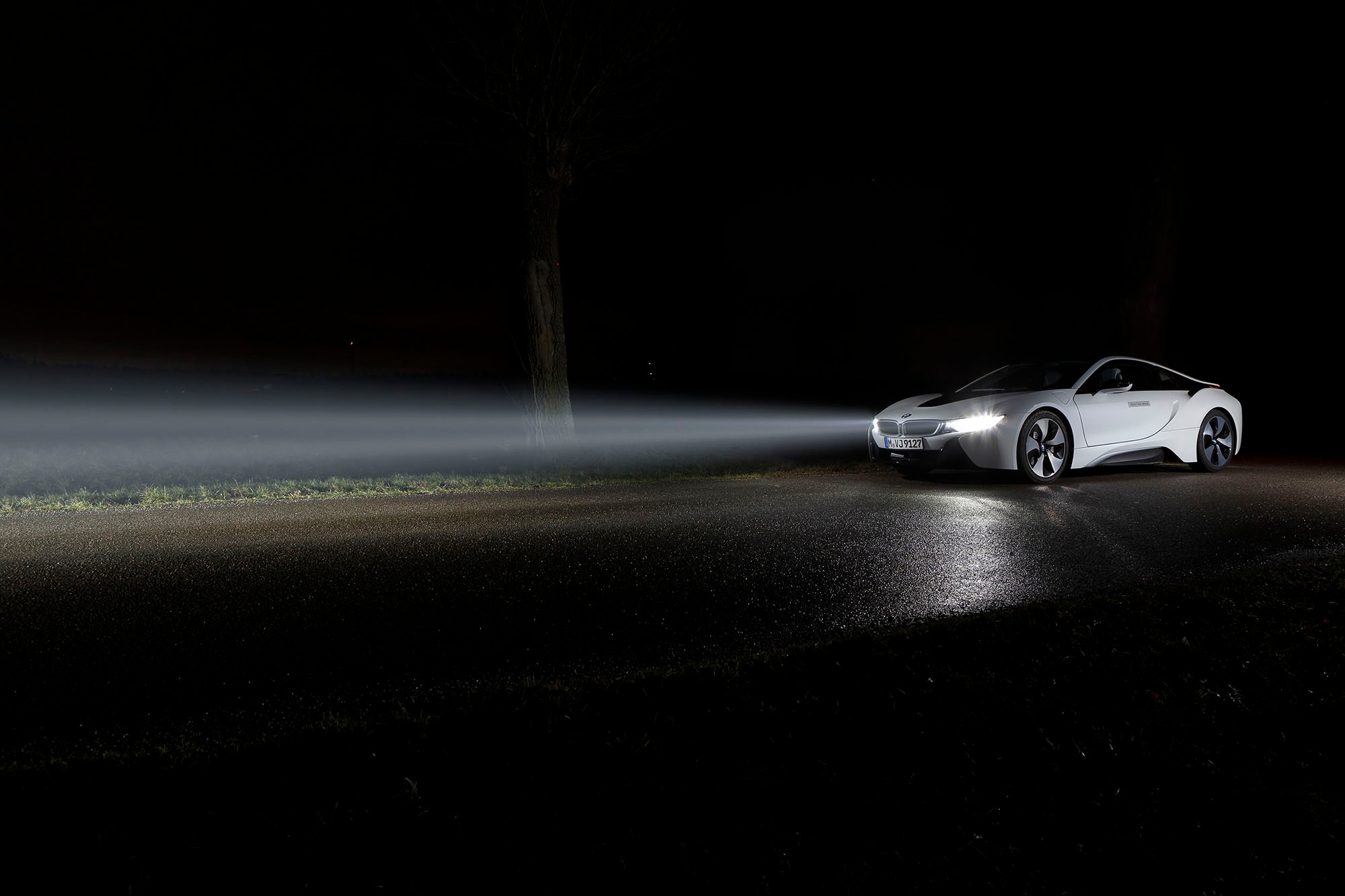 BMW Laserlight technology on a white BMW i8 driving in the dark with the headlights on