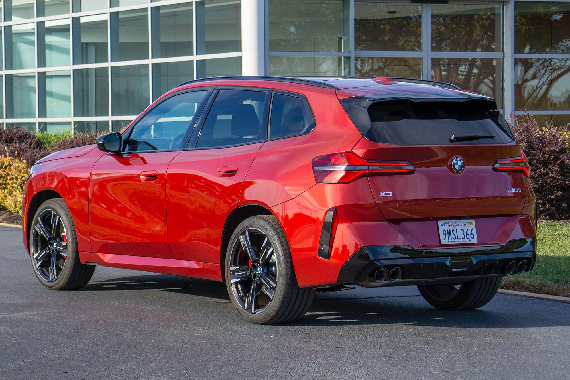 Rear left view of a red 2025 BMW X3 