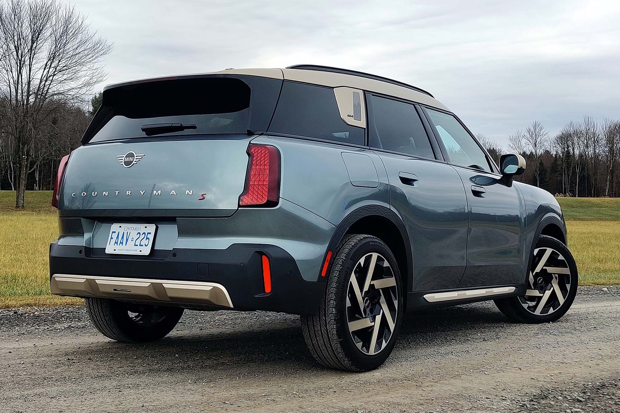 2025 Mini Countryman S All4 in Smokey Green with a field and barren trees in the background.