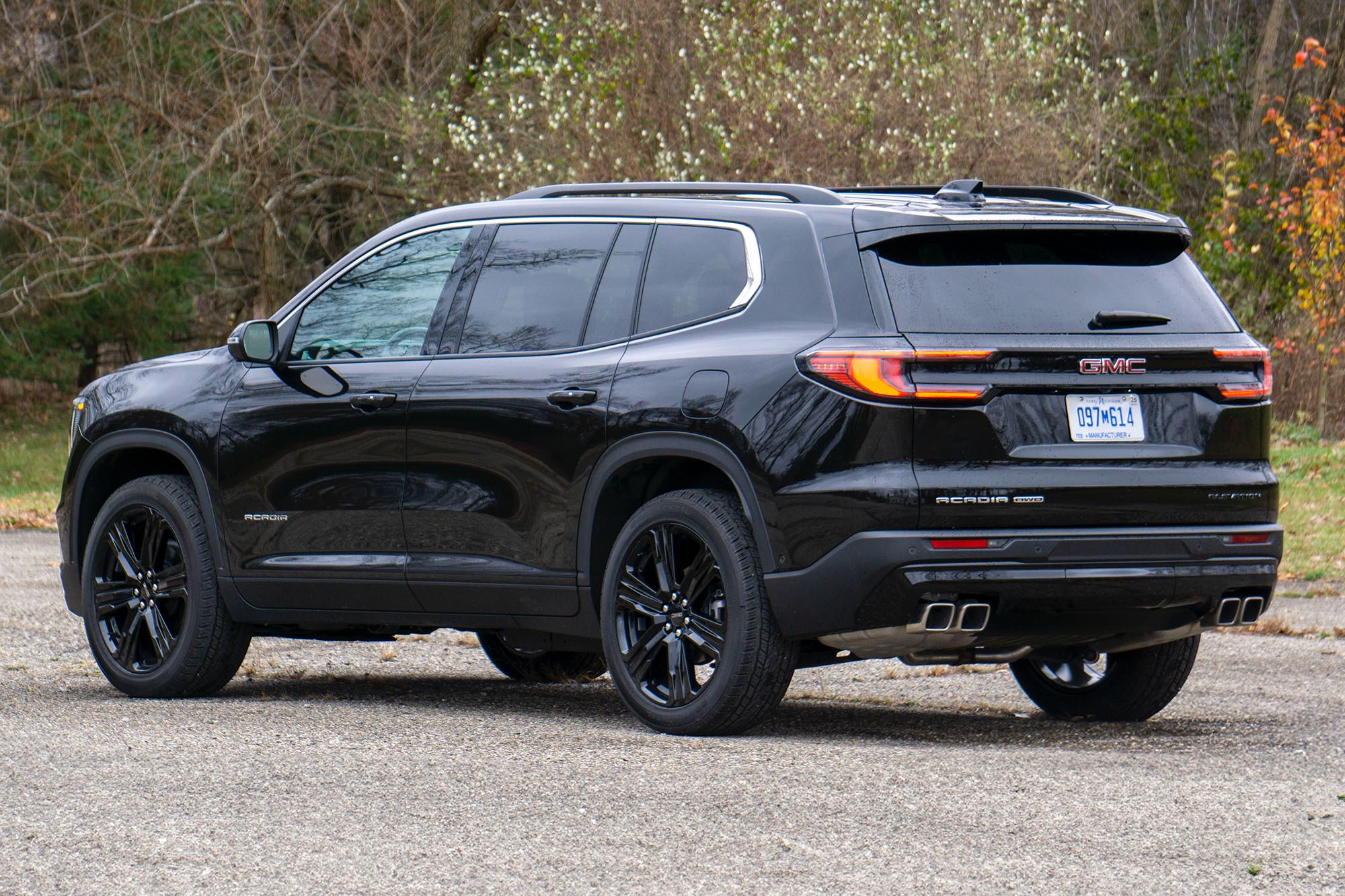 2024 GMC Acadia Elevation Black Edition in Ebony Twilight with trees in the background.